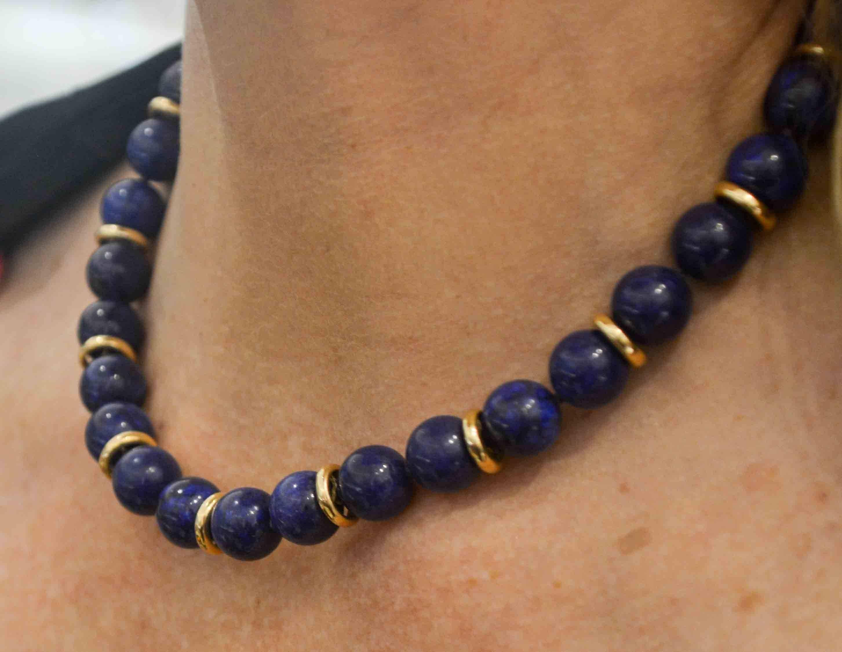 Serene shades of blue are on display in this marvelous Lapis Lazuli bead necklace that is accented with 14 karat yellow gold discs and a 14 karat gold clasp. Equally at home with a casual shirt or sophisticated dress, this Lapis Lazuli bead necklace