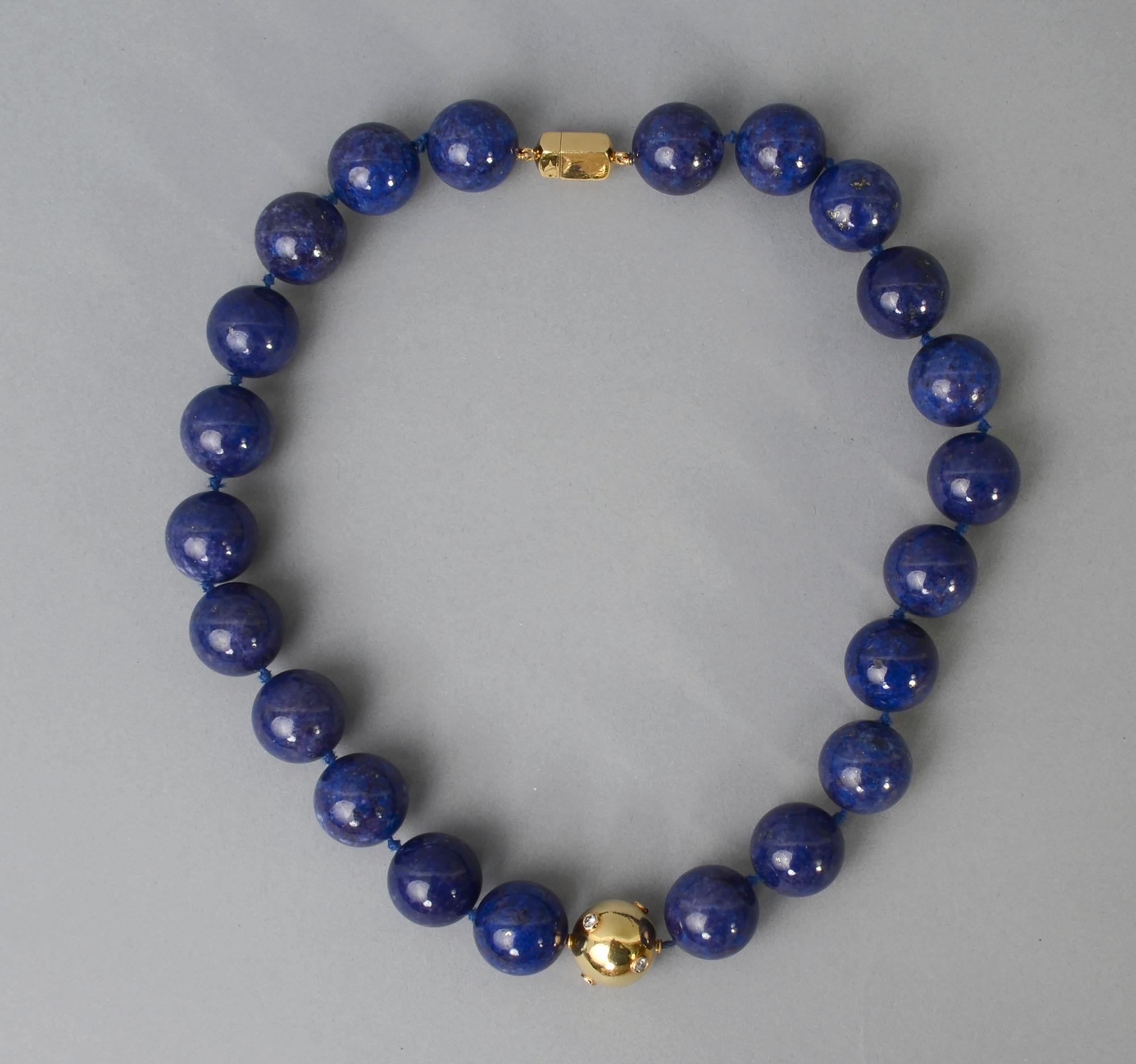Richly colored natural lapis lazuli round beads necklace enhanced by a gold ball with diamonds.  The necklace has a wearable length of 19 inches. The lapis beads are 18.5mm. The six diamonds weigh slightly over half a carat. The ball and clasp are
