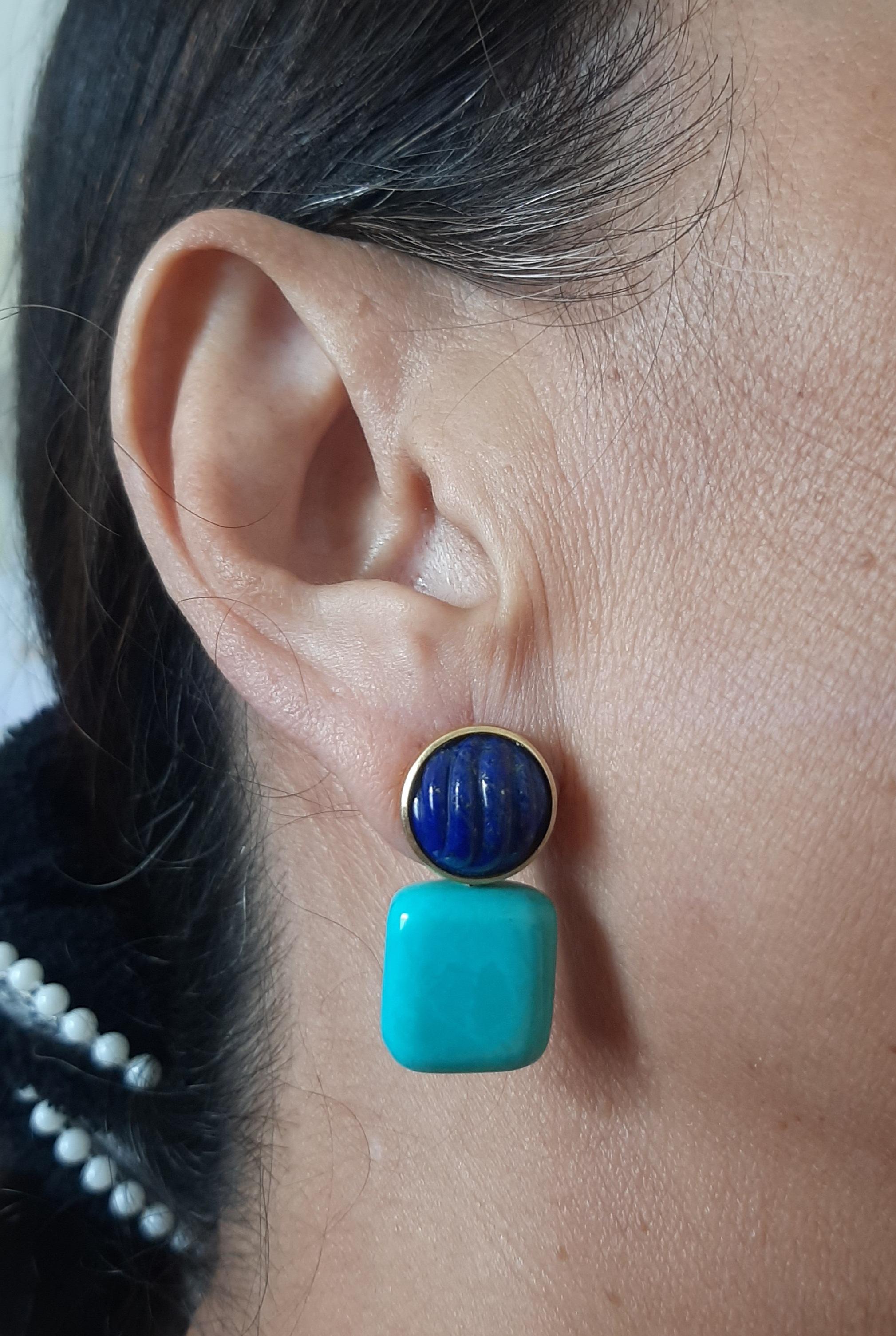 Ces boucles d'oreilles simples mais élégantes sont faites à la main et comportent 2 Cabs de Lapis Lazuli ronds sculptés de 13 mm de diamètre sertis dans un chaton en or jaune 14 Kt au sommet duquel sont suspendues 2 Turquoises authentiques en forme