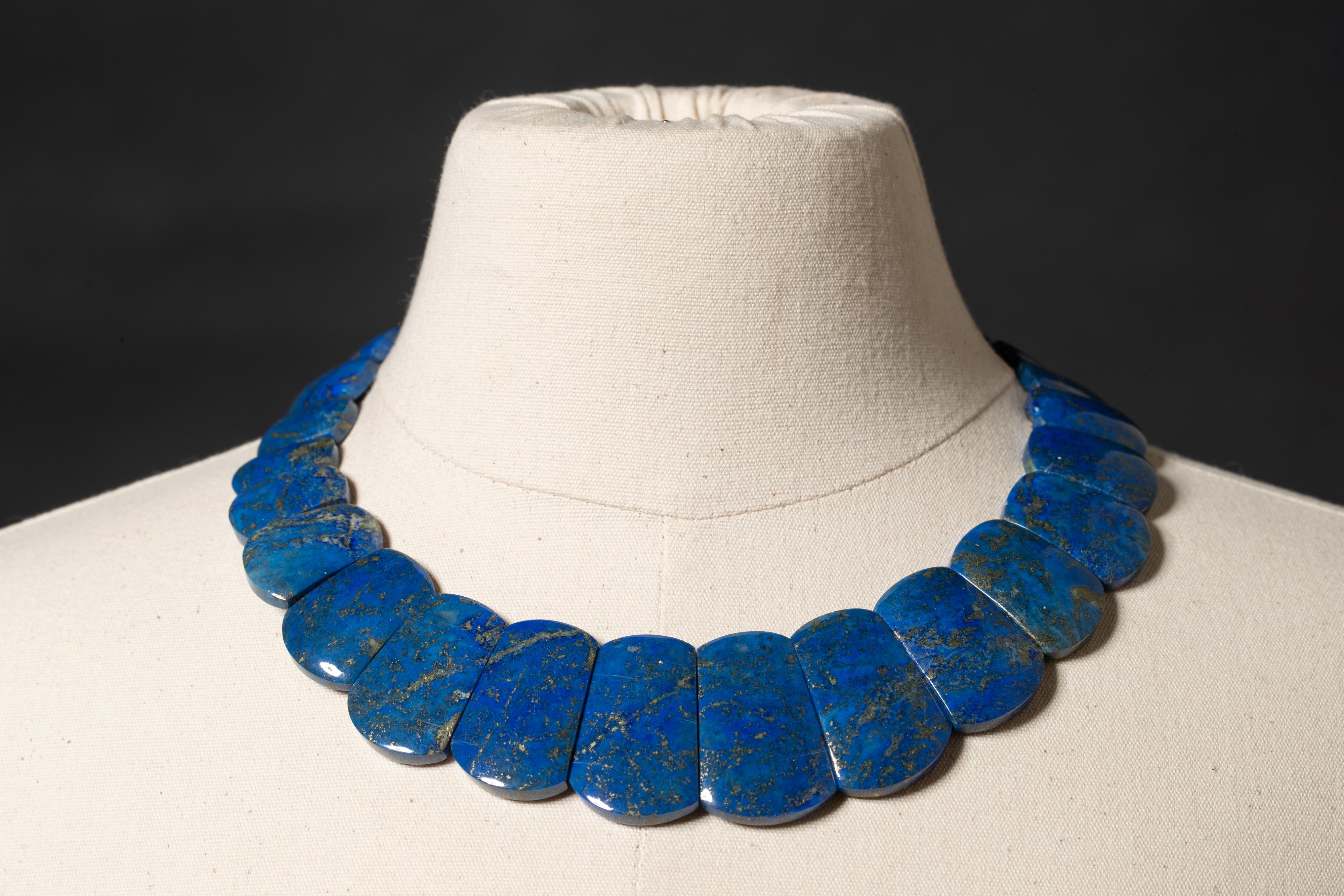 Rare and unusual cut and size of lapis lazuli beads with the natural flecks of pyrite indigenous to the stone.  Slightly graduated.  Sits flat and nice on an open neckline or inside a shirt.  Sterling silver clasp.  By Deborah Lockhart Phillips.