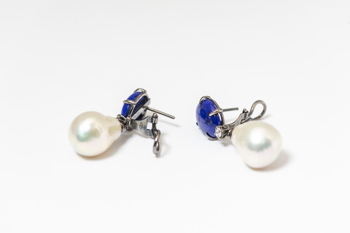 Découvrez ces sublimes boucles d'oreilles pendantes, véritable chef d'œuvre d'artisanat réalisé dans nos ateliers. Elles combinent harmonieusement lapis-lazuli, perles baroques et diamants sertis dans un magnifique or noir 18 carats.

Ces boucles