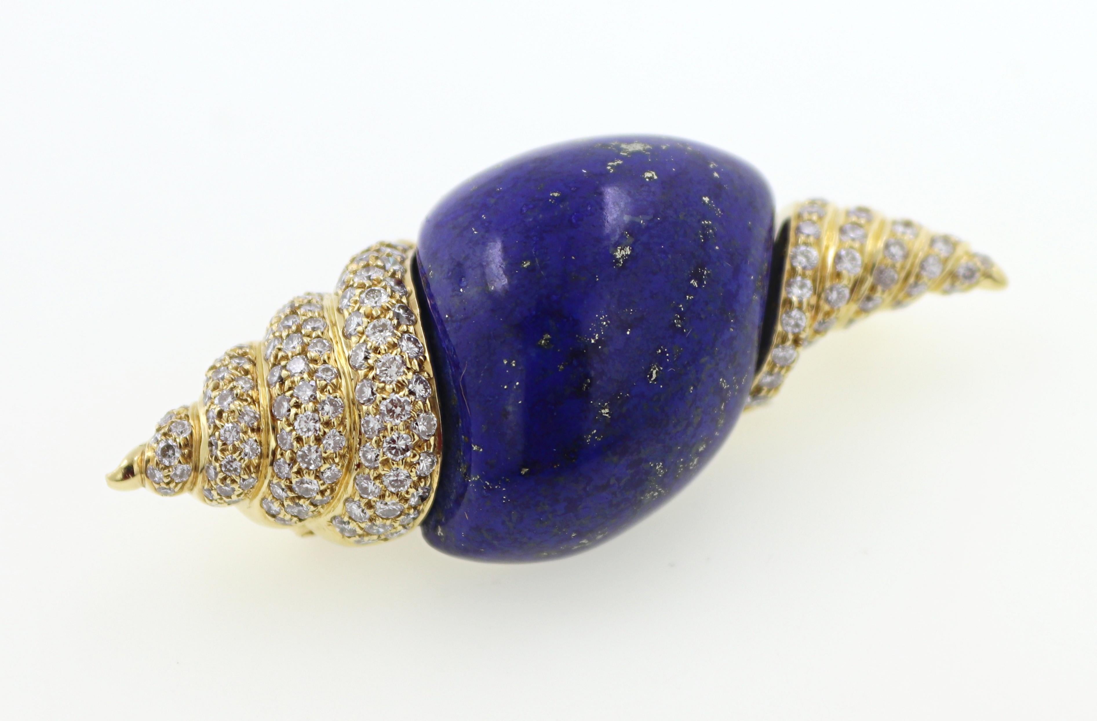 Featuring a carved lapis lazuli center, accented by 134 full-cut diamonds, 2.00  carat total weight, VS, I-J, pave set
in an 18k yellow gold seashell mounting, 53.23 X 22.9 X 17.3 mm, marked RNR, English hallmarks gold,
750, London, 1990, Gross