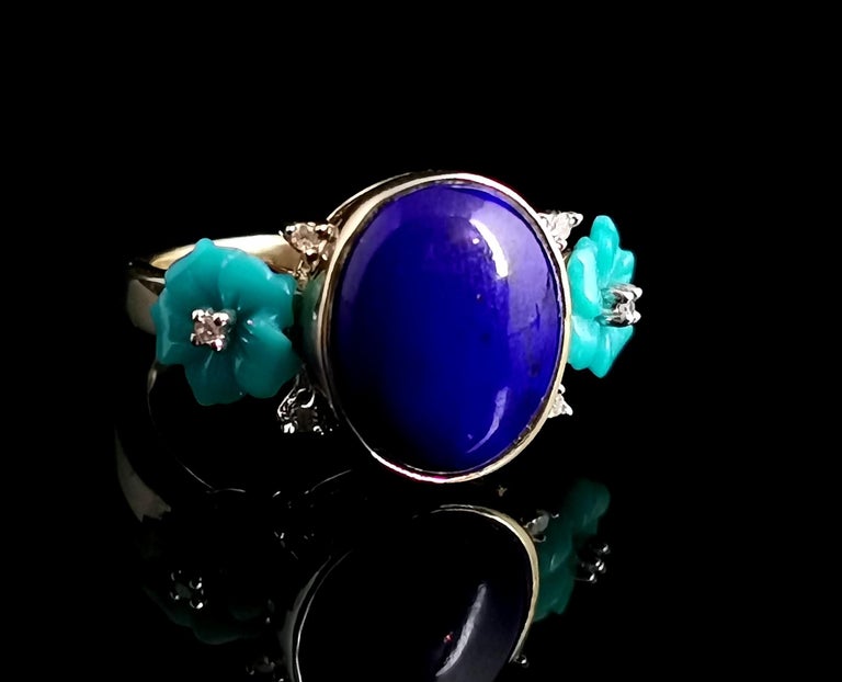 A gorgeous contemporary Lapis lazuli, Diamond and reconstituted turquoise ring in 9 karat yellow gold designed by Heng Ngai.

The ring features a large cabochon lapis lazuli with deep blue tones and almost black marbling the lapis is bezel set into
