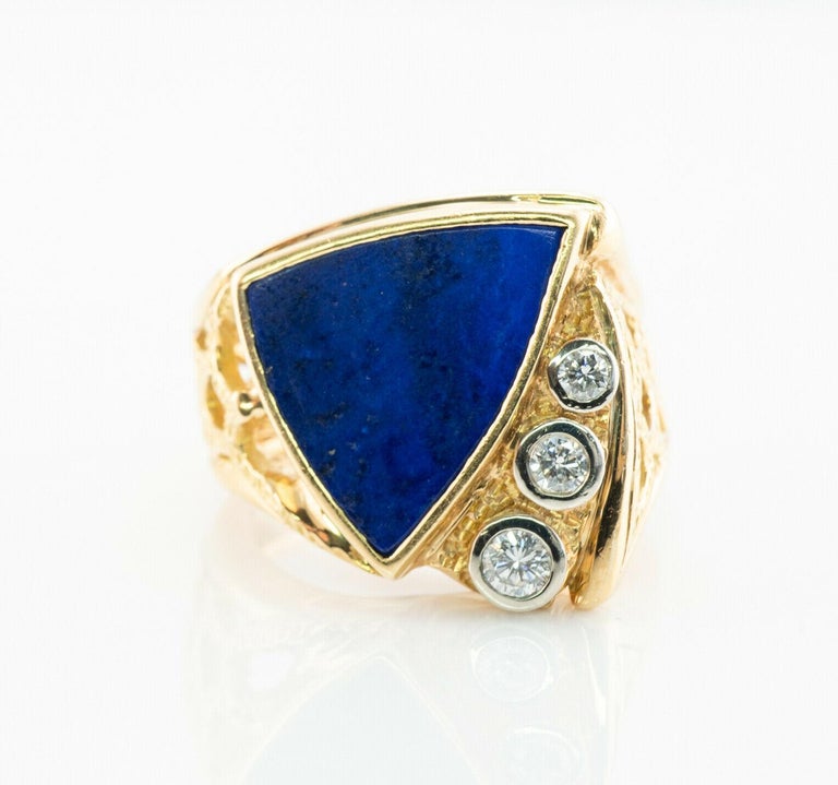 This unusual vintage ring is finely crafted in solid 18K Yellow Gold (carefully tested and guaranteed) and set with natural blue Lapis Lazuli and Diamonds. The center stone measures approximately 15mm x 14mm. Gorgeous royal blue color. Three bezel