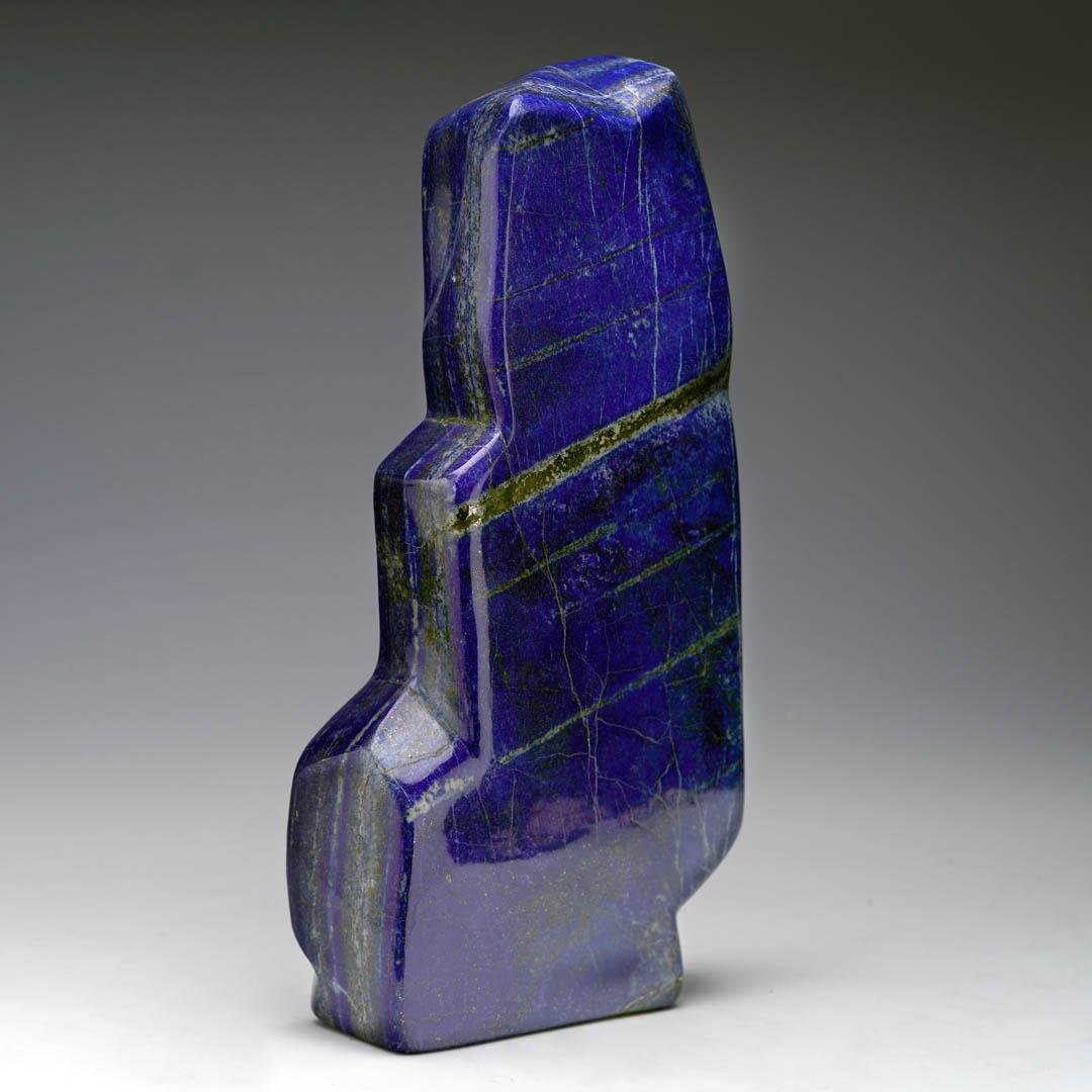 This lustrously hand-polished Lapis Lazuli freeform makes a striking natural sculpture, perfect for boldly elevating any space. Its bold blue hue and elegant lines – including many thick, shimmering Pyrite inclusions – bring a luxe, serene touch to