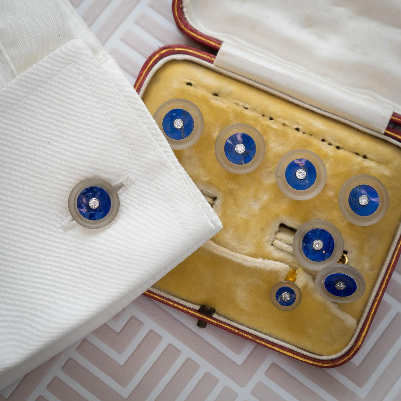 A lapis lazuli, frosted rock crystal and diamond dress-set, with central round brilliant-cut diamonds with a circular surround of lapis lazuli, and a further surround of frosted rock crystal, and 18ct gold fittings. Circa 1930.