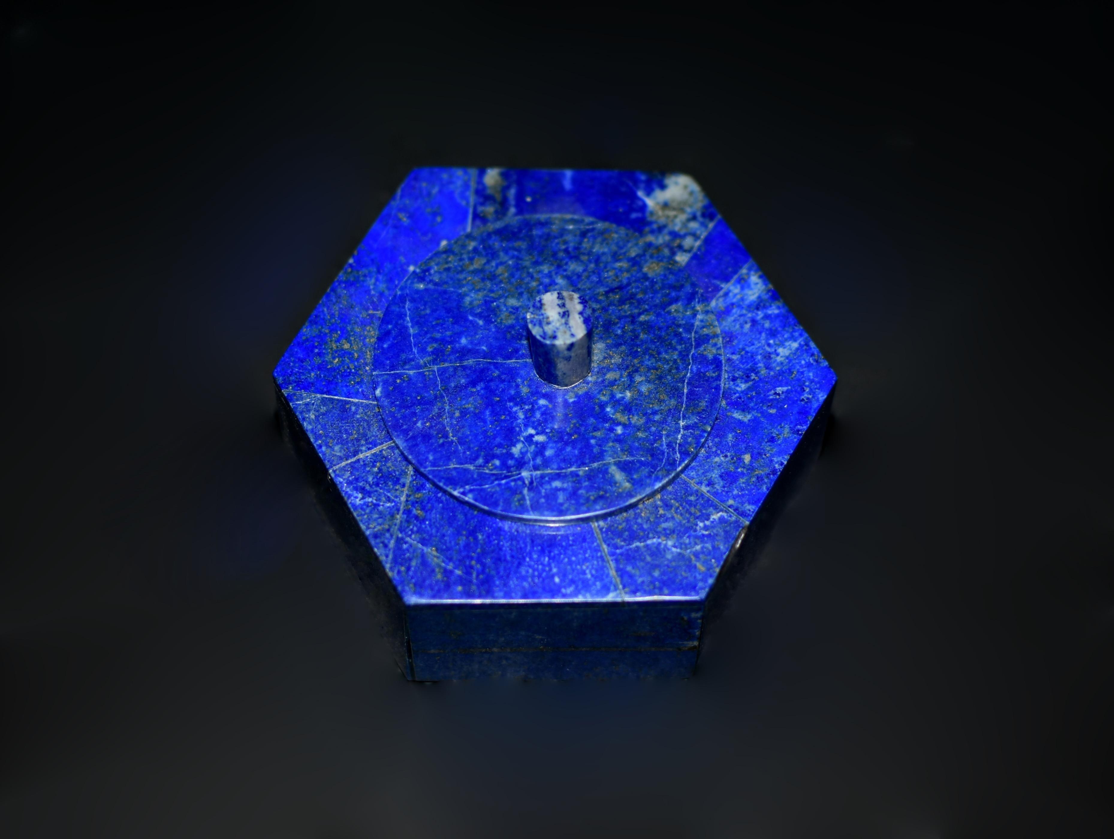 Una hermosa caja hexagonal, elaborada con el mejor lapislázuli natural procedente de Afganistán. La caja tiene una tapa redonda adornada con un elegante remate, mientras que el interior está forrado de lujoso mármol de Carrara. El cautivador tono
