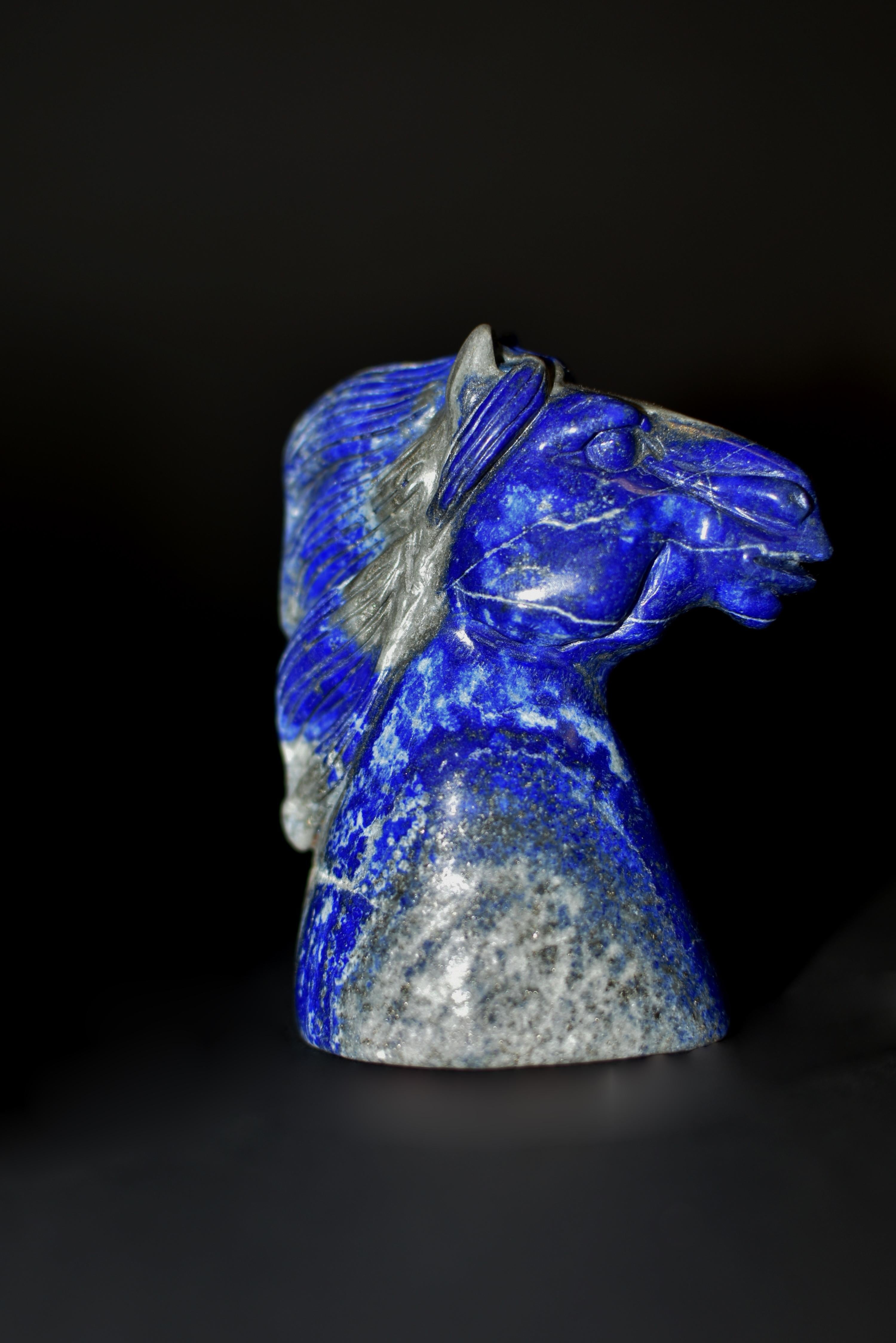 Un magnifique buste de cheval sculpté à la main en lapis-lazuli naturel de catégorie AAA. Le cheval au cou robuste et à la crinière balayée par les vents, à la bouche légèrement ouverte et aux grands yeux alertes. Le Lapis, d'un beau bleu cobalt
