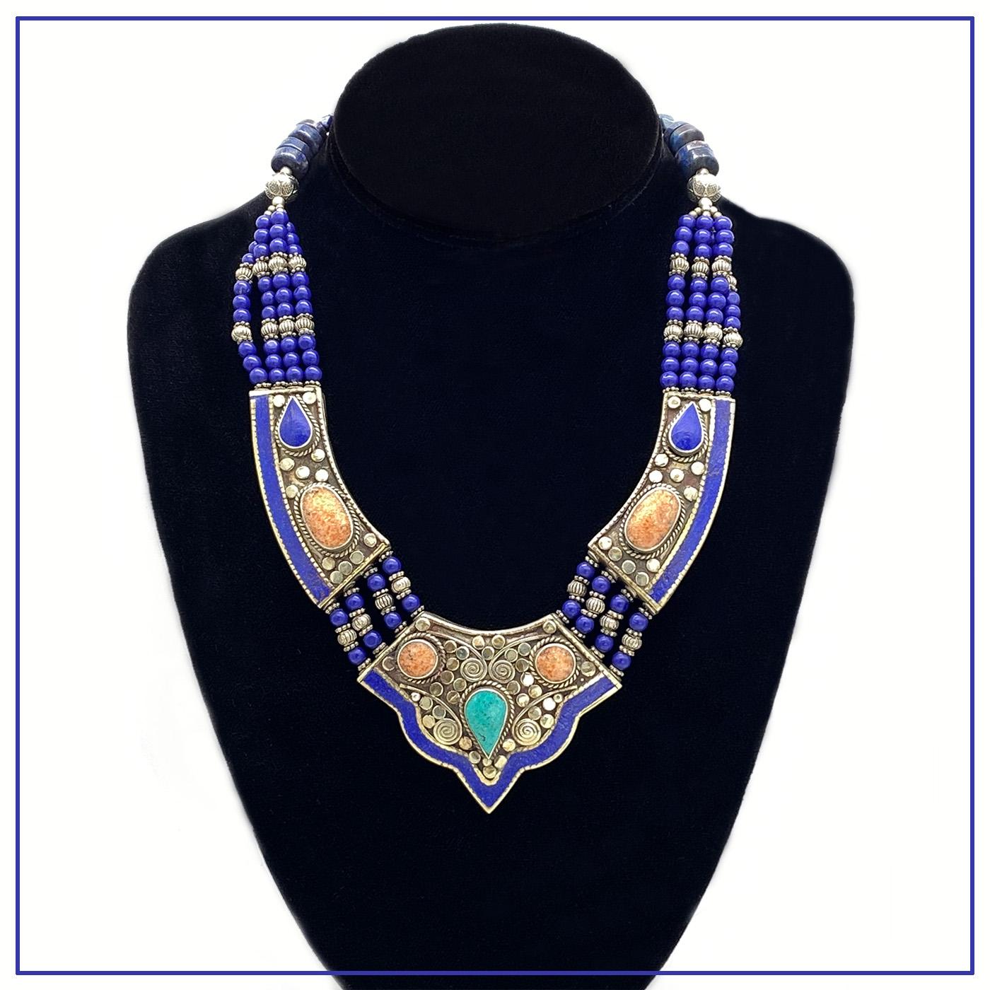 This is a Lapis Lazuli multi-strand necklace from Turkey.  Four strands of small beads connect with three large silver sections with composite mineral inlays and worked silver patterns. It is marked 925 on the clasp. A sophisticated piece drawing