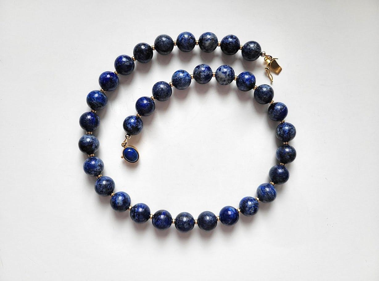 Le collier mesure 47 cm de long et les perles rondes et lisses mesurent 12 mm.
Les perles de lapis-lazuli sont bleu foncé. Le lapis-lazuli présente des taches visibles de calcite et de pyrite dorée.
Couleur naturelle, non teintée. Aucun traitement