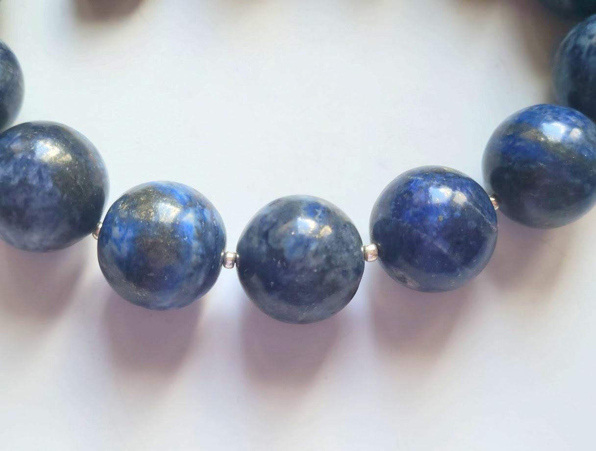 The length of the necklace is 17.5 inches (44.5 cm). The size of the smooth round beads is 21-22 mm.
The lapis lazuli beads are indigo, a midnight tone. Lapis lazuli has visible calcite and golden pyrite flecks. It is a natural color, not dyed. 
The