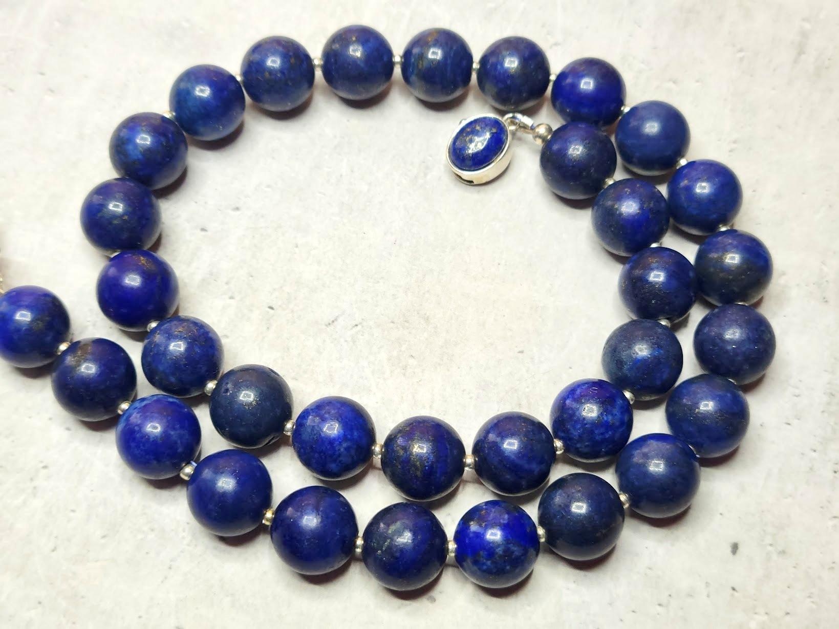 Die Kette ist 17,5 Zoll (44,5 cm) lang, und die glatten runden Perlen sind 12 mm groß.
Die Lapislazuli-Perlen sind dunkelblau. Lapislazuli hat sichtbare Kalzit- und goldene Pyritflecken.
Natürliche Farbe, nicht gefärbt. Es wurden keine thermischen