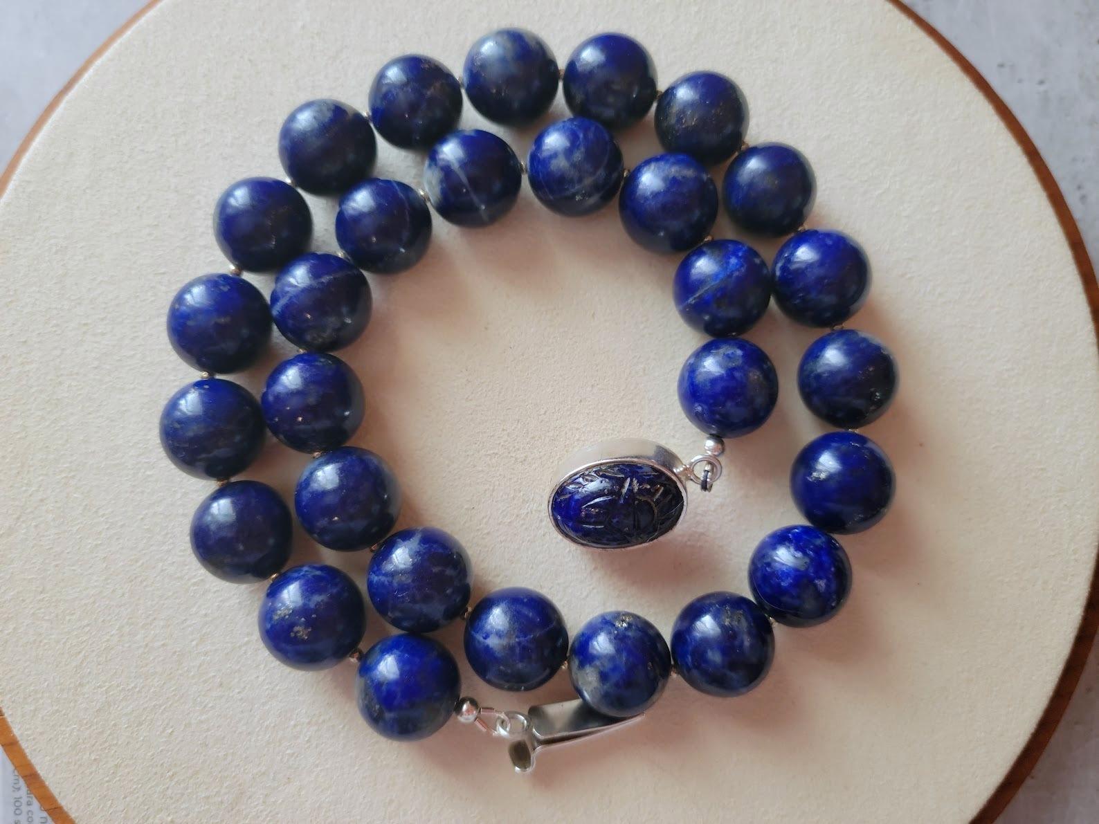 La longueur du collier est de 18,5 pouces (47 cm). La taille des perles rondes lisses est de 14 mm.
Les perles de lapis-lazuli sont indigo, de couleur minuit et très saturées. Le lapis-lazuli présente des taches visibles de calcite et de pyrite