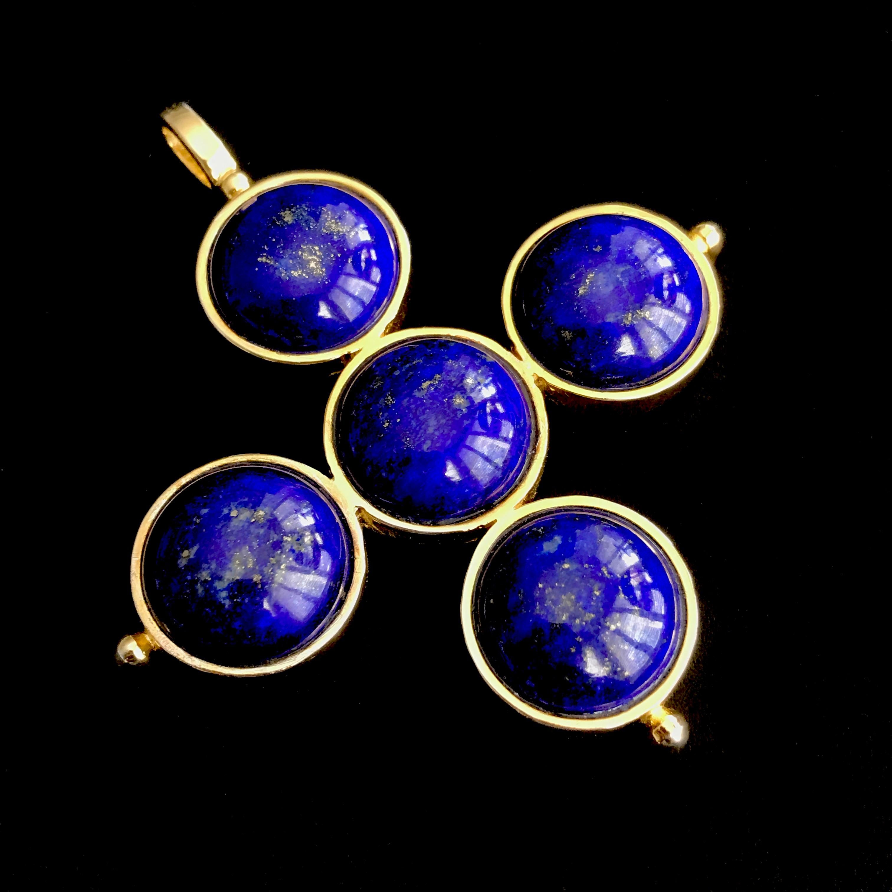 Un pendentif simple mais saisissant, formé de cinq grands cabochons ronds de Lapis Lazuli.  pierres précieuses, chacune mesurant 18 mm, serties dans un collier discret ; les bornes sont terminées par une petite perle en or. 

Le pendentif est