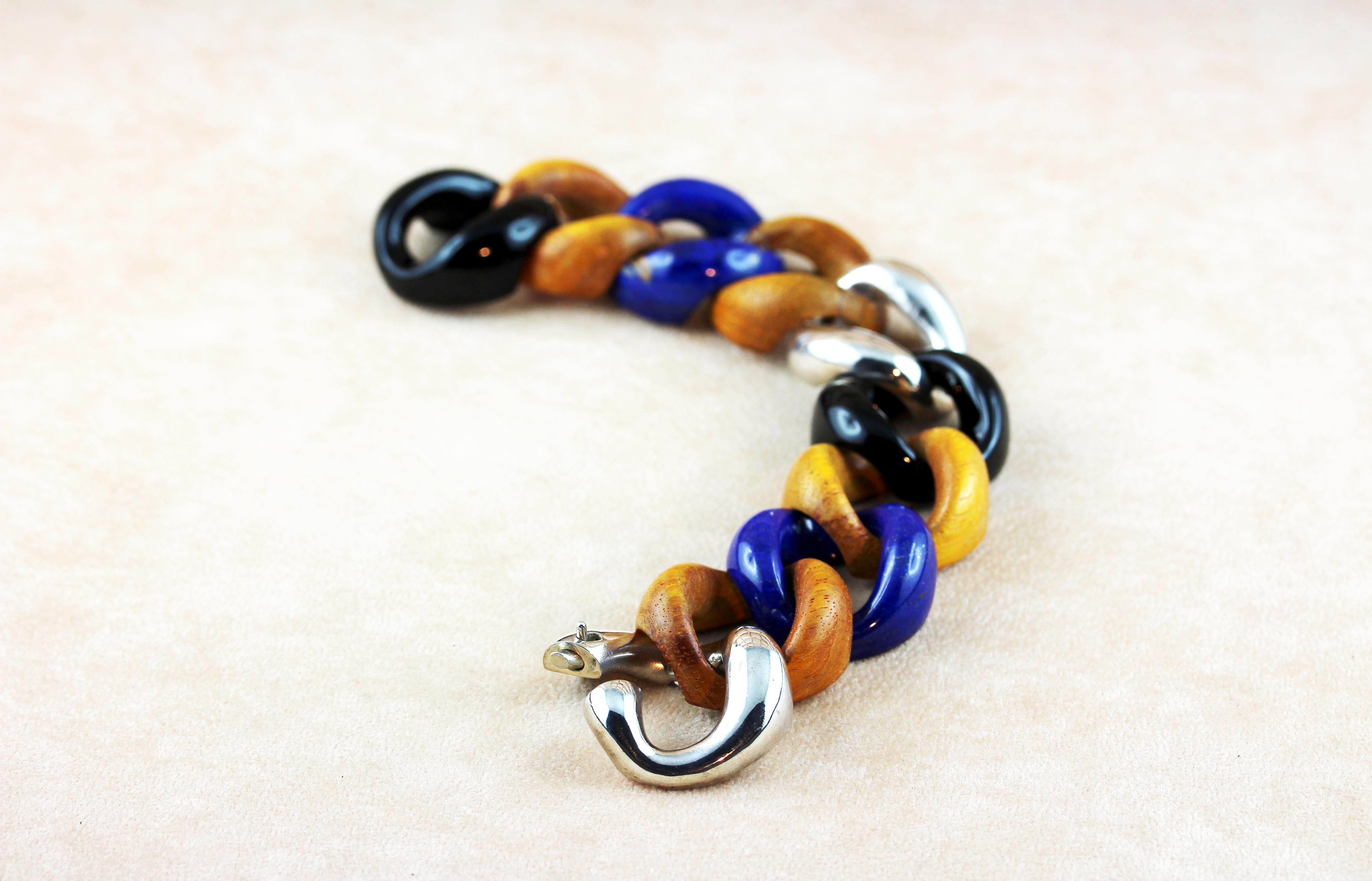 In this elegant groumette bracelet orange wooden rings are alternate with onyx rings and lapis lazuli rings, creating a striking combinations of textures, finishes, and colors, mixing sophistication and a contemporary allure.
The clasp and a ring in