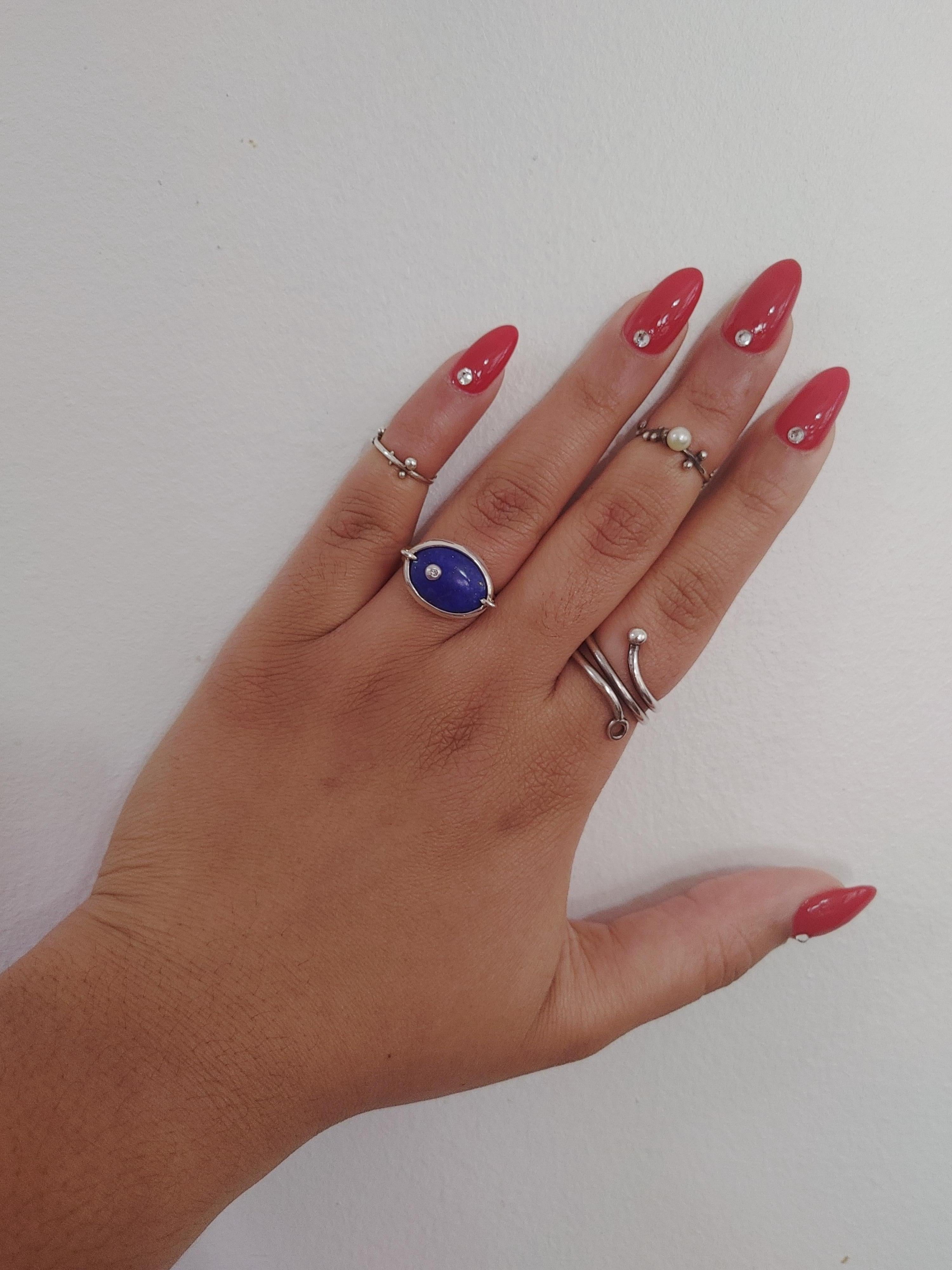 The Caribbean Night Sky Oval Ring captures the Caribbean sky at night with tiny glimpses of stars in Lapis Lazuli. It includes the signature rosebuds found within Angely Martinez Jewelry, in silver with a burnished set diamond.  

The ring’s shape