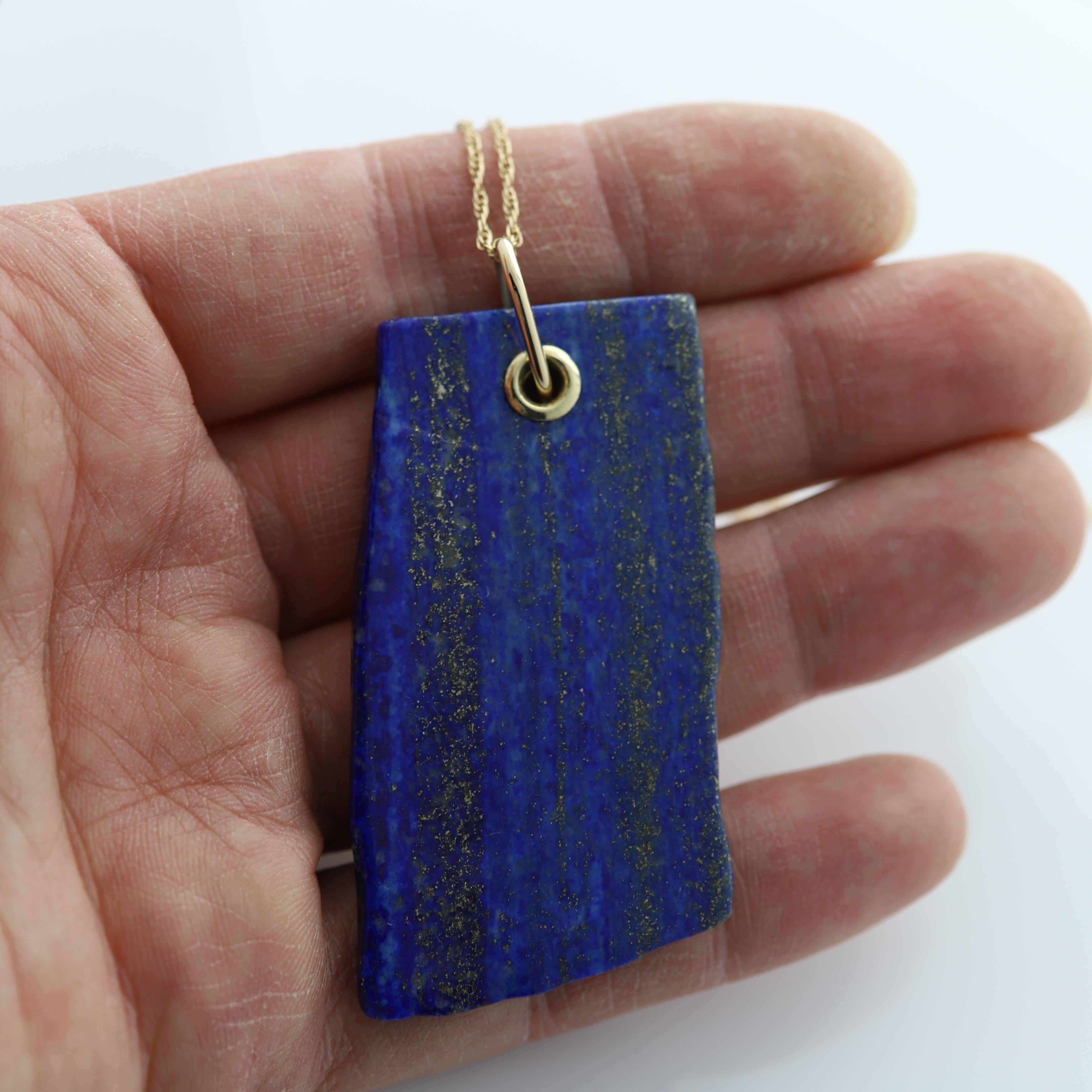 Lapis Necklace
Unique Shape of Lapis Stone with nice texture set with 14k components and chain.
Approx size of stone 2.5' Inch Long.
14k Yellow Gold 
Chain 16' Inch
Lapis with Rich Blue Texture and Gold tone flakes.
Imperfections due exist due to