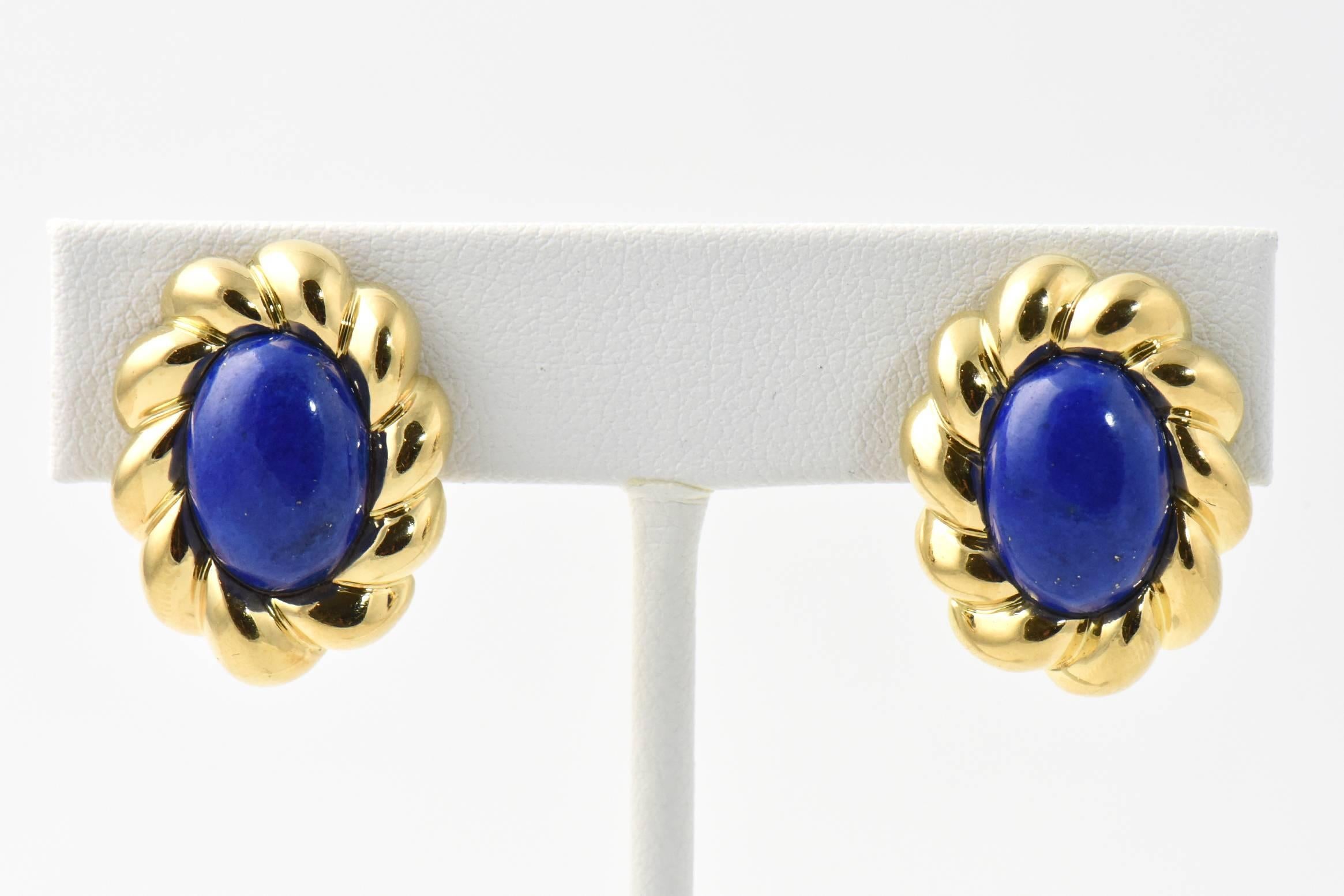 Oval cabochon lapis lazuli earrings framed in sculpted 18K gold. Clip backs. Some wear.

