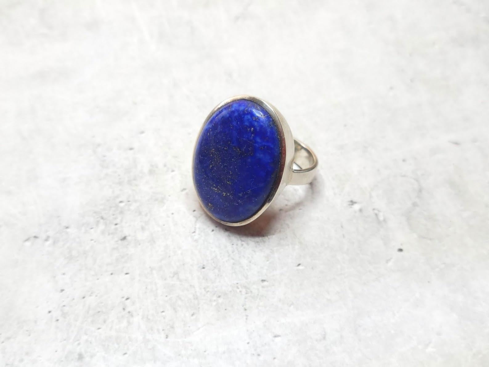 This gorgeous modern, comfortable ring is from a high-quality lapis lazuli cabochon in the sterling silver set.

The Afghan lapis lazuli stone is approximately 30mm long and 20mm across. 
The US size of the ring is 10. 
The weight of the ring is