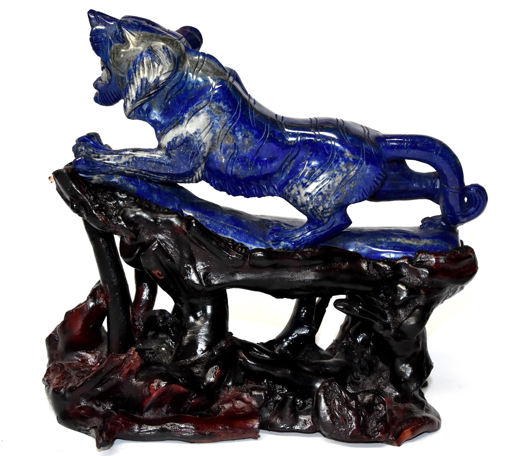 A beautiful all natural lapis lazuli tiger sculpture. The 2 lb stone's is violet blue with stunning glittering of gold, a contrast that creates a mesmerizing visual effect. Fantastic carving work shows off the tiger's muscles and paws. A fantastic