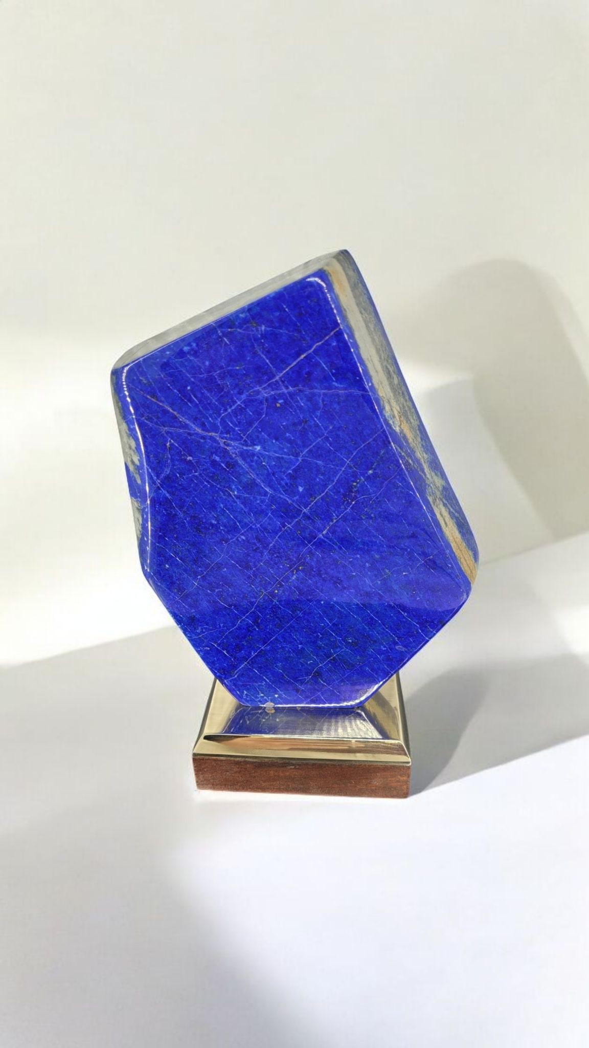 Diese Mineralstufe aus Lapislazuli mit Pyriteinschlüssen auf einem Holz- und Messingständer ist ein großer Klassiker. Lapislazuli wurde schon immer erforscht (sogar im antiken Ägypten) und geschätzt: für Schmuck, zur Herstellung von Pigmenten, zur