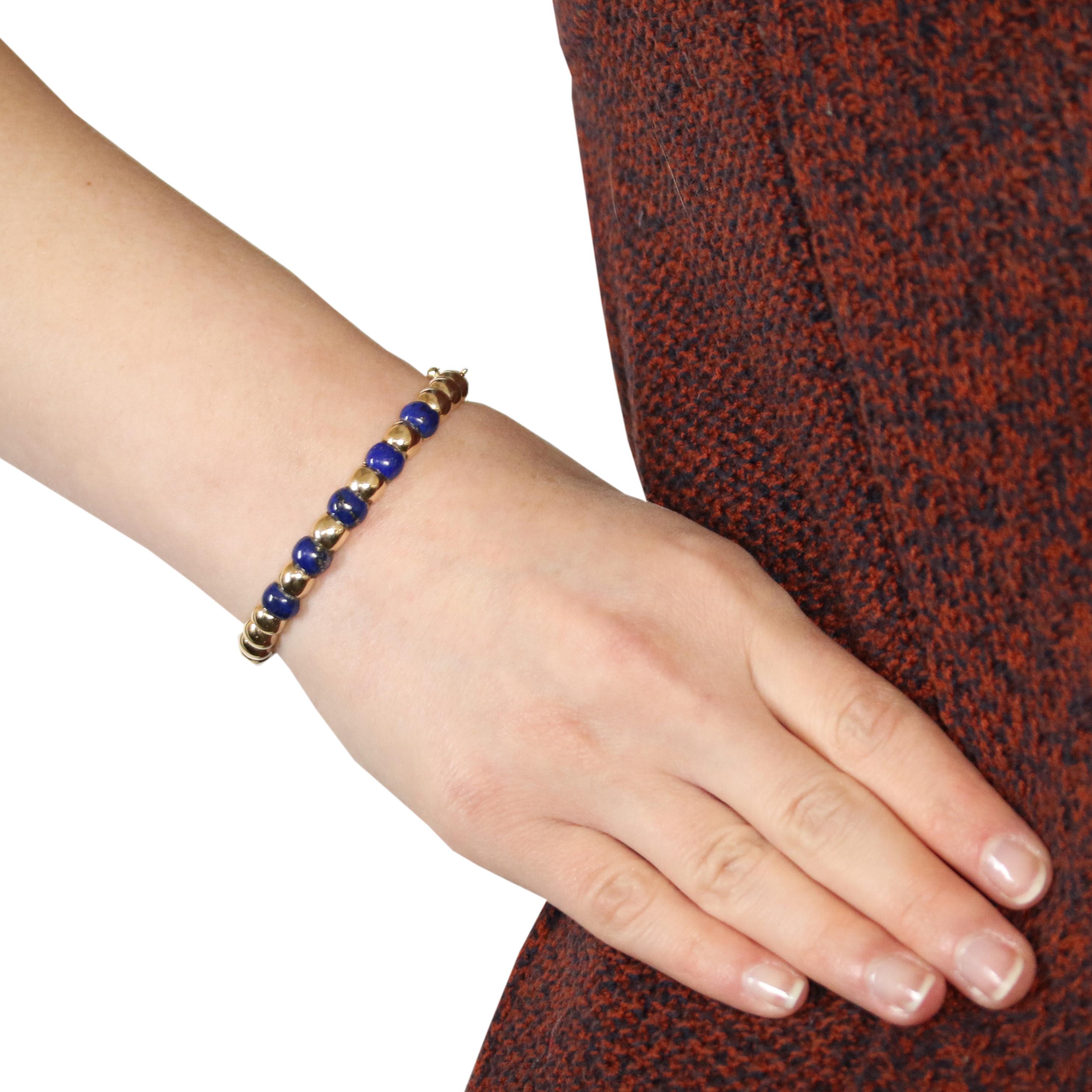 Brighten your wardrobe with a luxurious pop of color! Fashioned in an oval bangle style, this chic vintage bracelet showcases five rich blue lapis gemstones set in polished 14k yellow gold.   

Era: Vintage

Metal Content: Guaranteed 14k Gold as