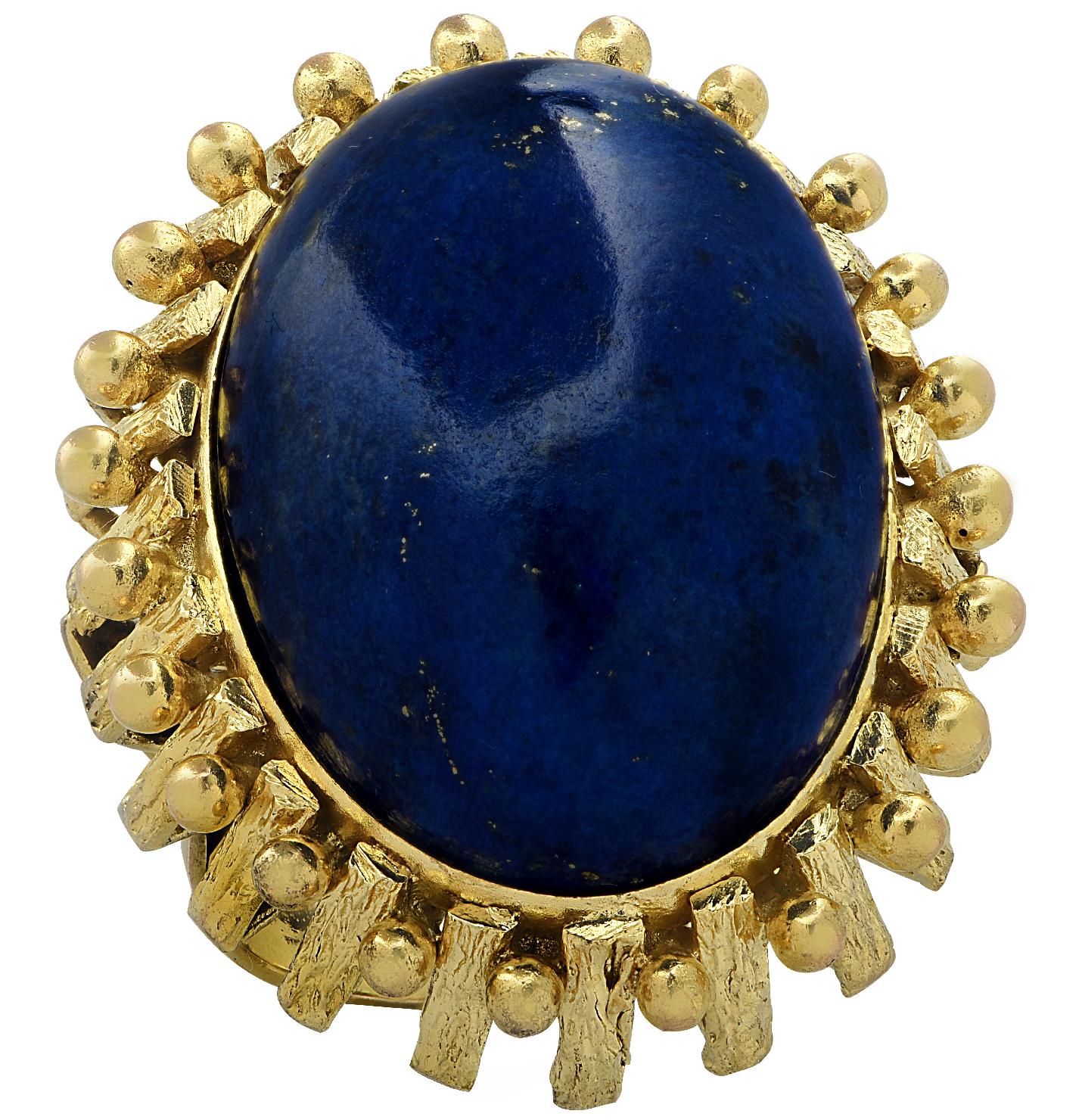 Striking cocktail ring crafted in yellow gold, showcasing an impressive oval Lapis Lazuli cabochon measuring 25mm x 17.8mm. The face of this majestic ring measures 1.2 inches in length and 1 inch in width. The shank measures 4.27 mm tapering gently