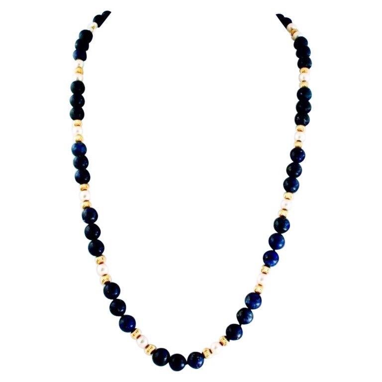 The lapis, pearl, and gold vermeil necklace with matching long dangle gold vermeil earrings is my own creation. The necklace is an earlier and more formal design. I made the earrings afterwards to accent the necklace’s gold tone beads. The long