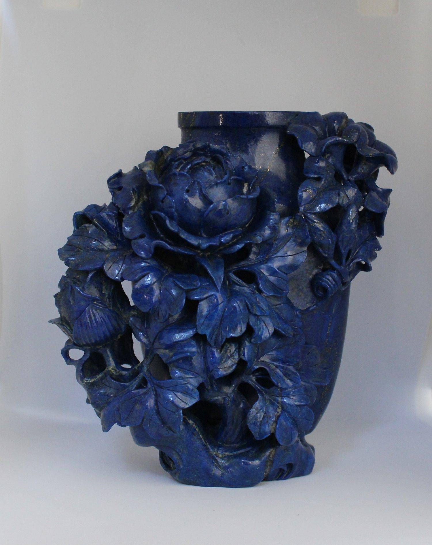 This late Qing Dynasty lapis vase is richly decorated with peony blossoms and leaves. On the right side of the vase near the top, there are morning glory flowers blooming out of spring vines. 

On the back of the vase, you can see the high quality