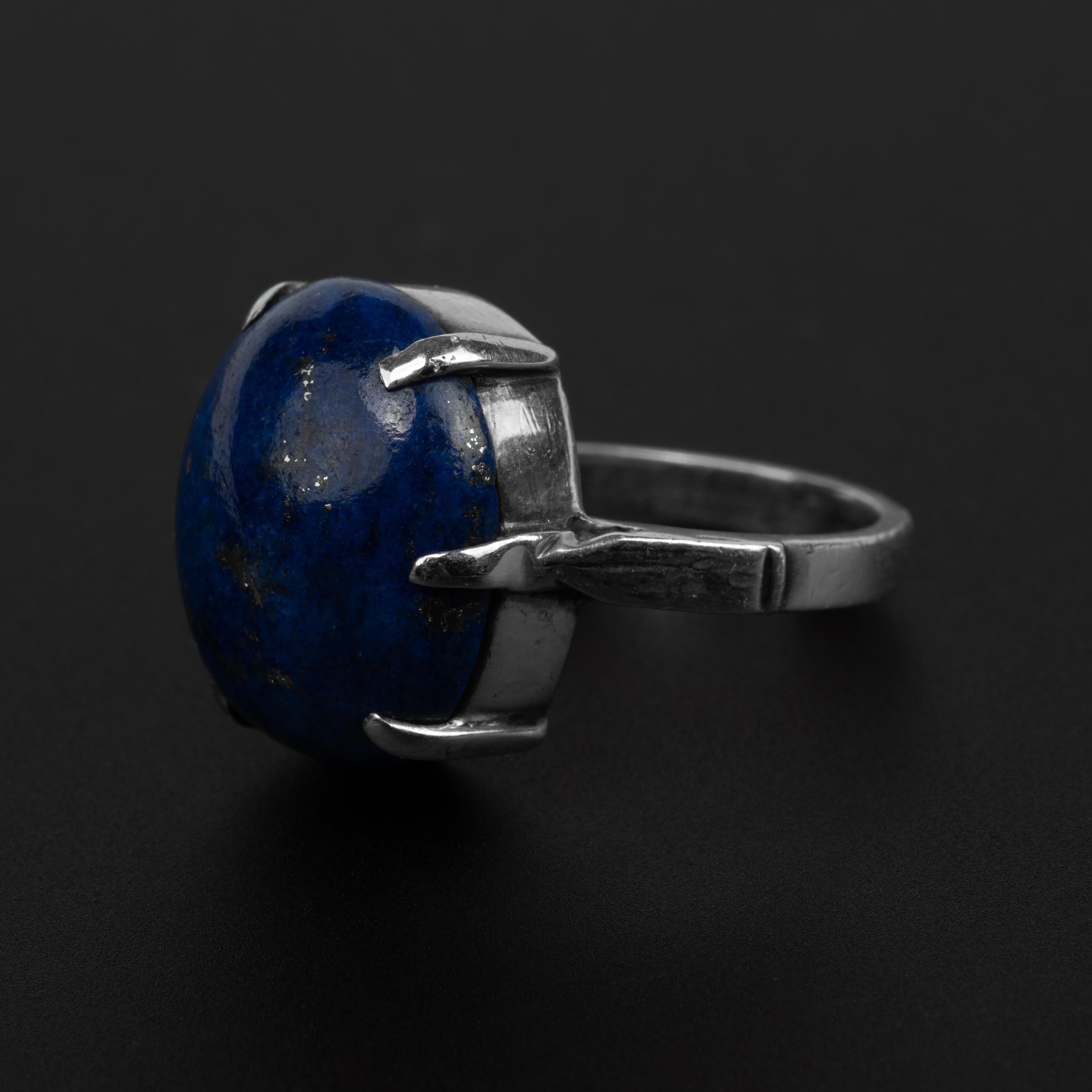 A vibrant deep blue cabochon of natural lapis lazuli —attractively flecked with pyrite— is secured by six tapered prongs in this handmade silver ring from the Arts & Crafts era, circa 1900.  I purchased this ring years ago in England and even though