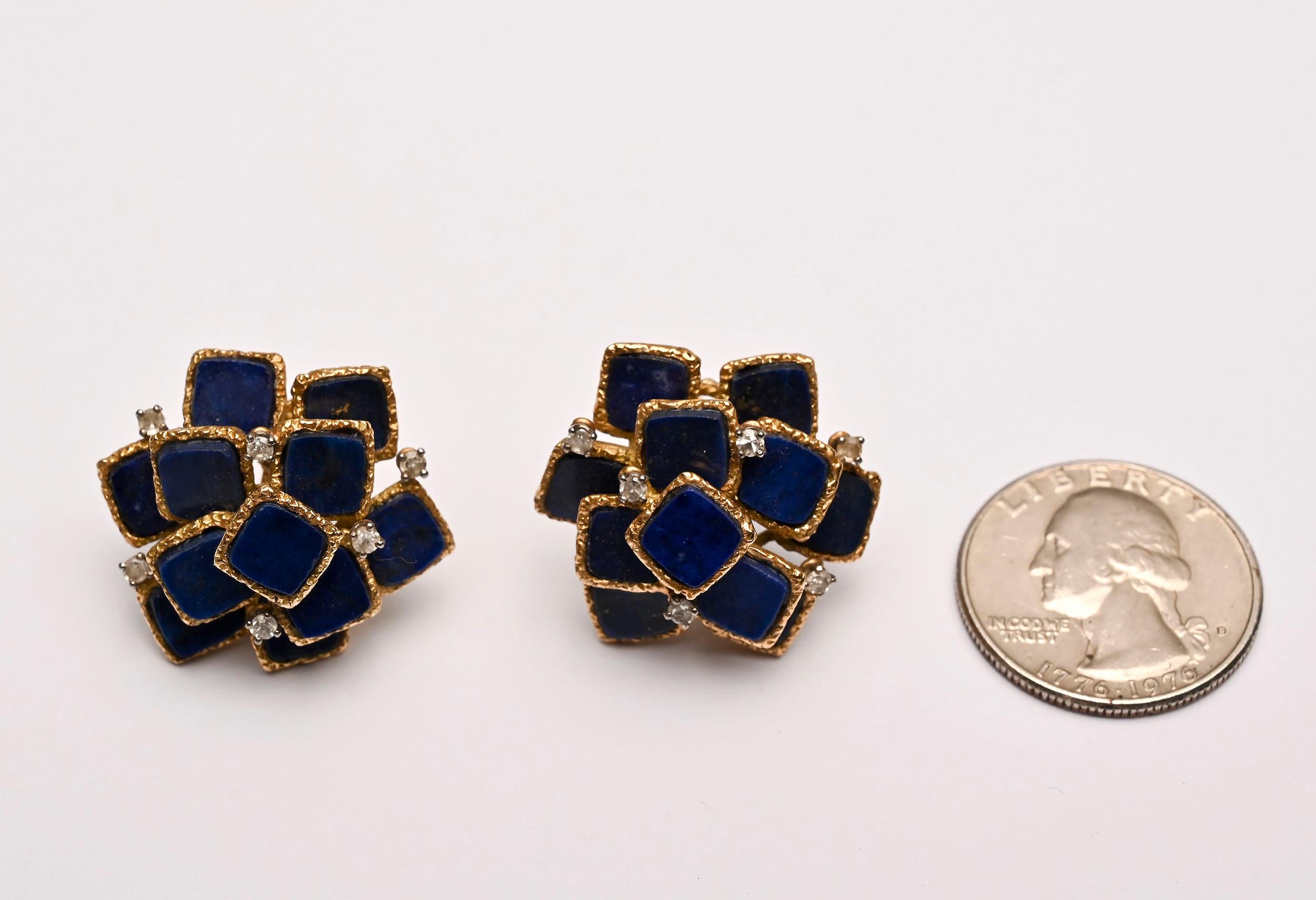 Eleven squares of lapis lazuli are set in a multi tiered arrangement in these earrings by J. Rossi. Each lapis stone is set in a textured gold band. Six diamonds weighing .05 carats each are set in each earring. Backs are posts and clips.