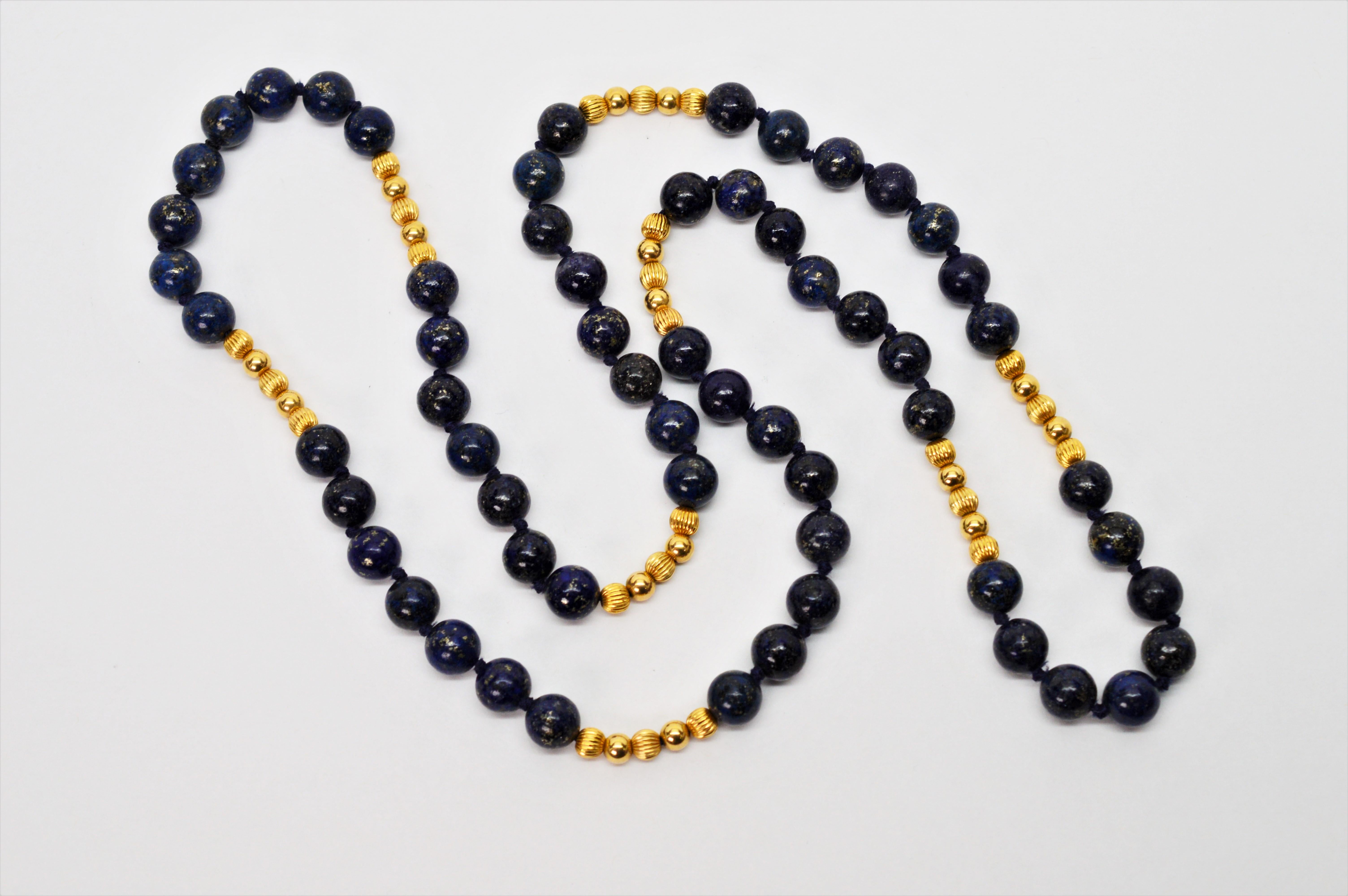 Thirty inches of beautifully marbled natural lapis beads accented with fourteen carat yellow gold beads, hand strung and knotted.
Slip over style and versatile piece perfect for dress or jeans. The strand is made of sixty round 9 mm indigo blue