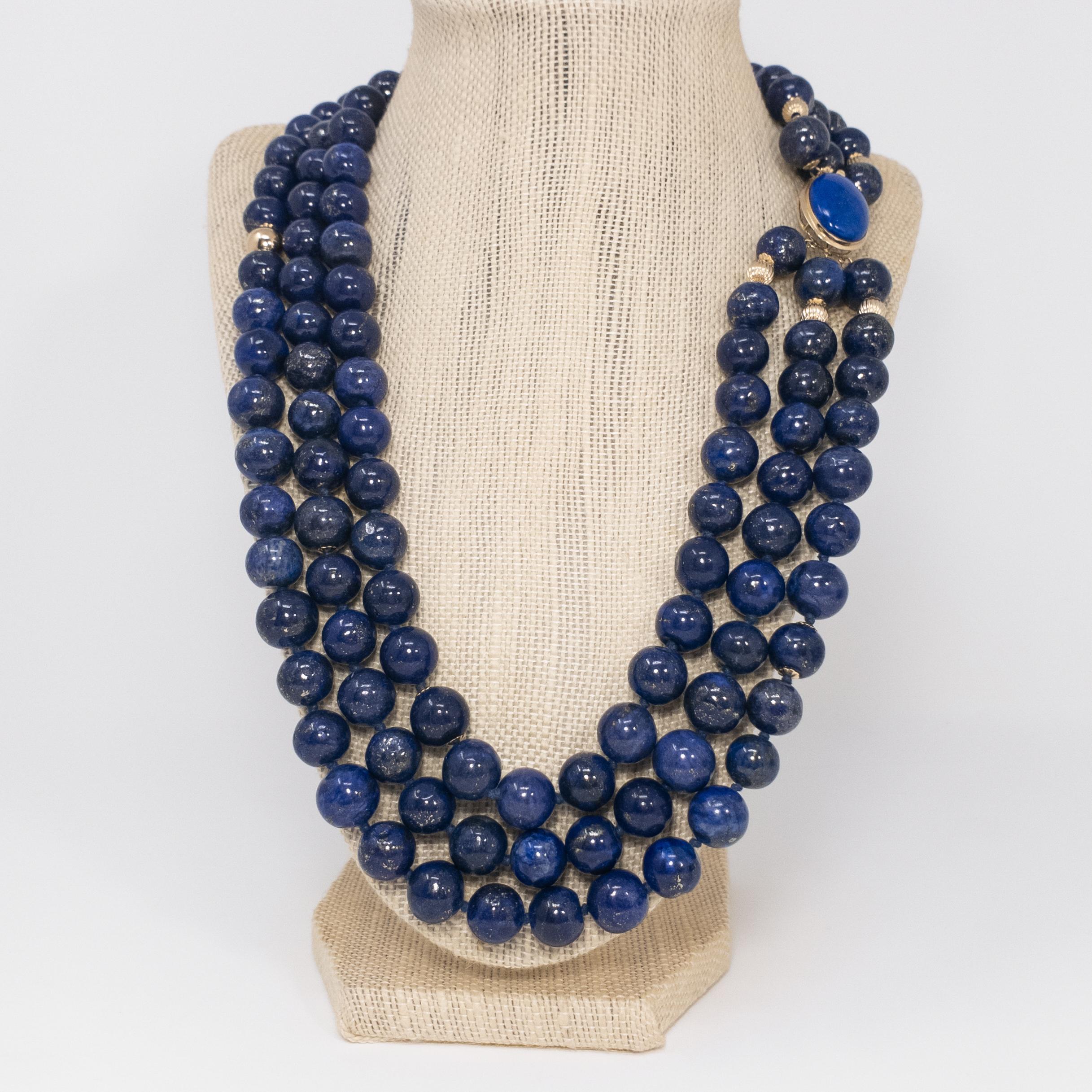 A striking and sophisticated triple-strand lapiz lazuli necklace. Each strand features genuine lapis lazuli beads, decorated with14 karat yellow gold beads and accents. The necklace is connected with a stunning 14K yellow gold, lapiz lazuli cabochon