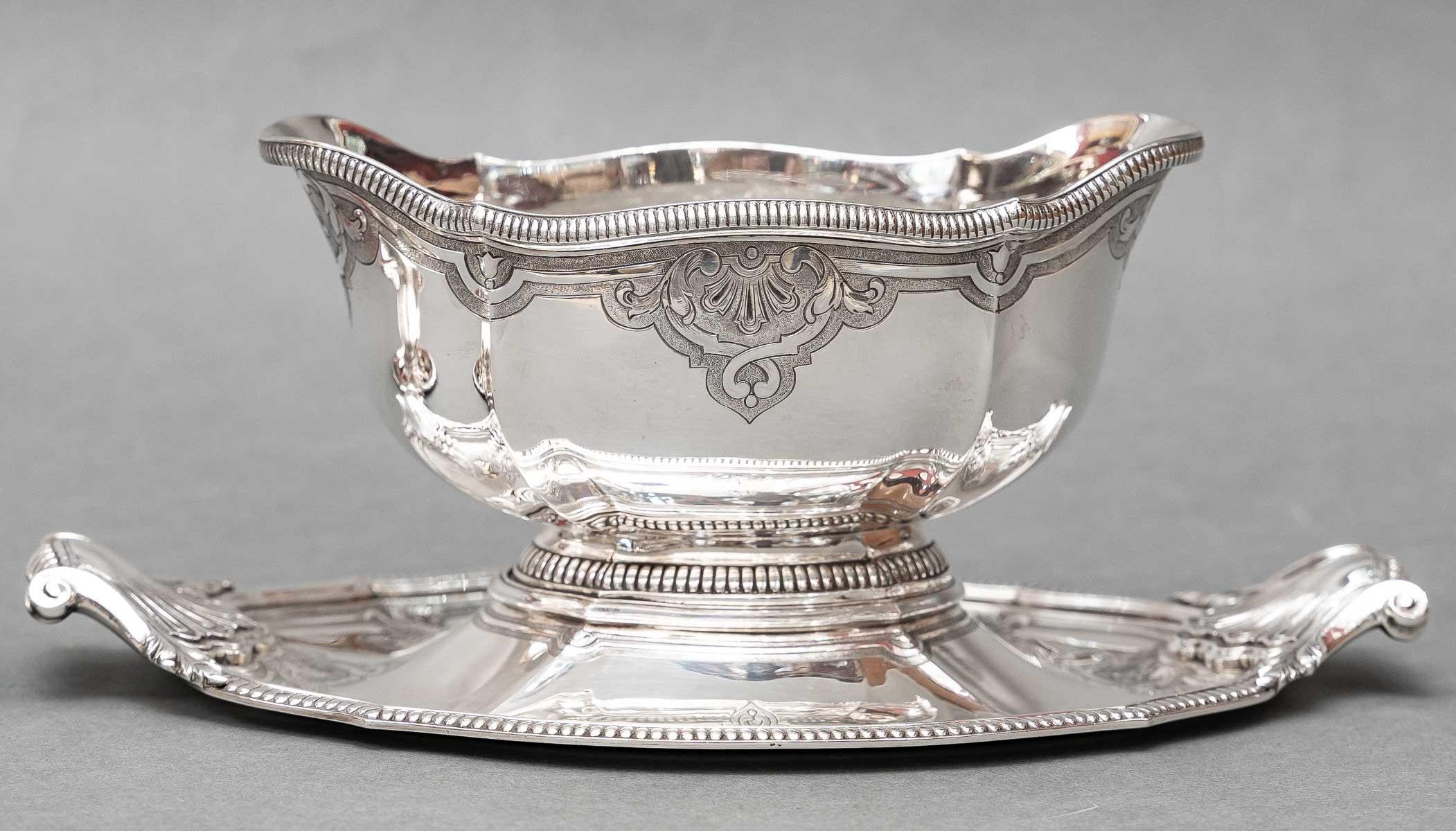 Pair of solid silver sauce boats, oblong in shape, adorned with a frieze of gadroons on the neck, the pinched ribbed body is engraved with a Bérain decoration on a matte background, the adherent tray chiseled with interlacing is flanked by side