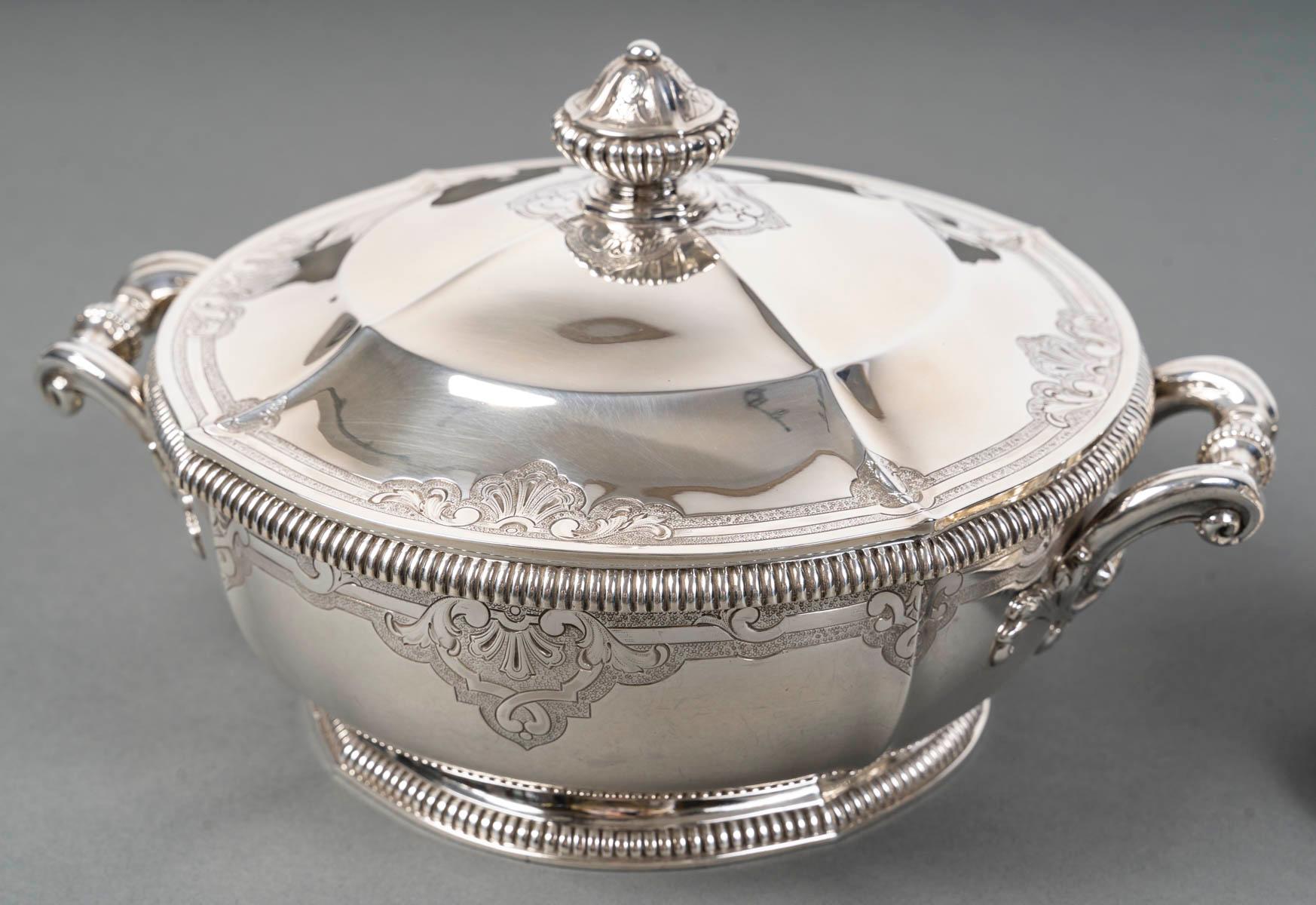 Juego de mesa de plata compuesto por una fuente para verduras y una salsera. Decoración de gadroons y un grabado Bérain sobre fondo mate. Las asas de los platos de verduras están enrolladas.

Dimensiones

- Plato para verduras: 21,5 cm de diámetro,