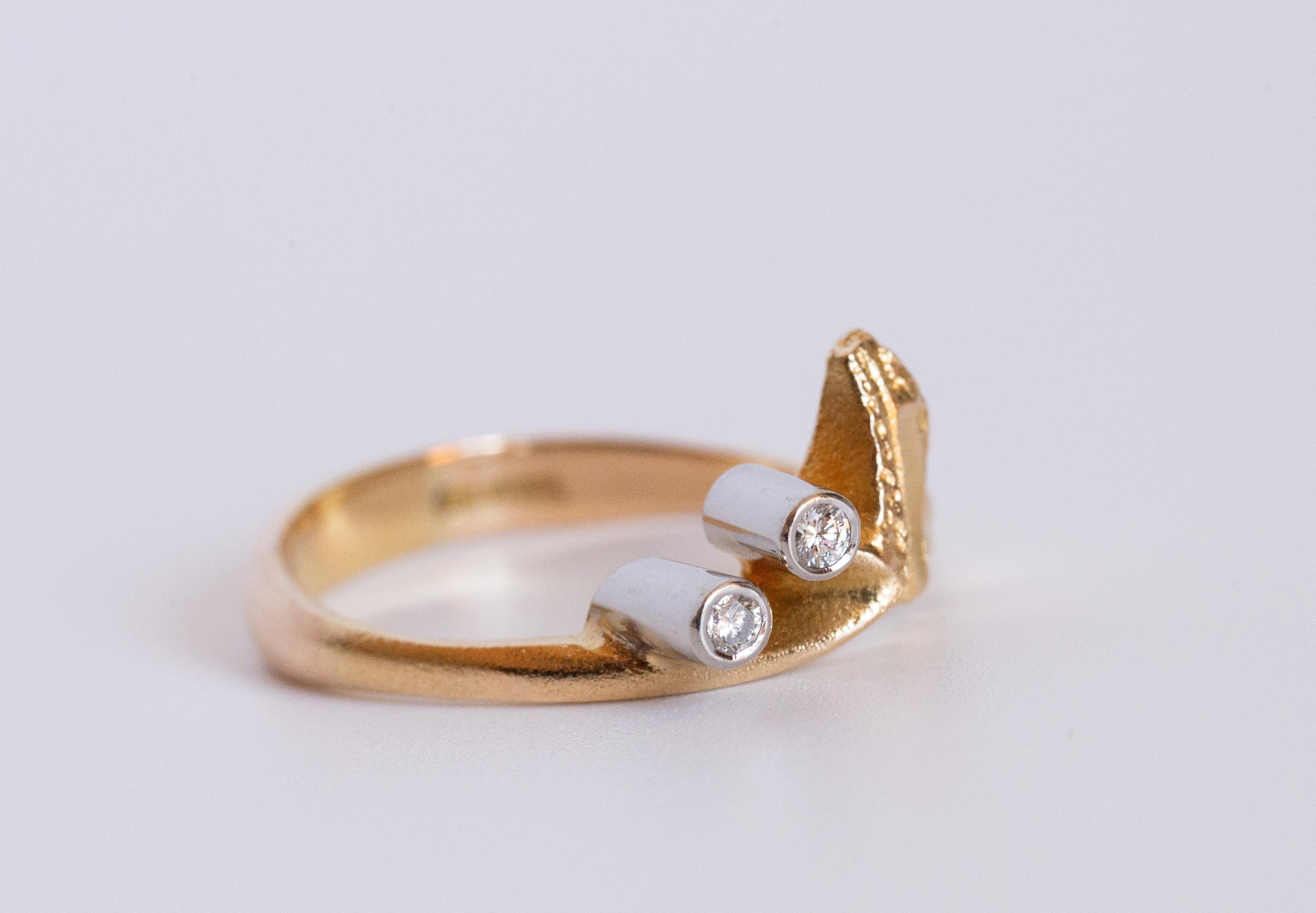 Une bague vintage brutaliste/moderniste conçue par Bjorn Weckstrom pour Lapponia en 1998. La bague est en or jaune 18 carats avec des diamants. Le centre de la bague présente un design asymétrique et une finition mate. La bague est sertie de deux
