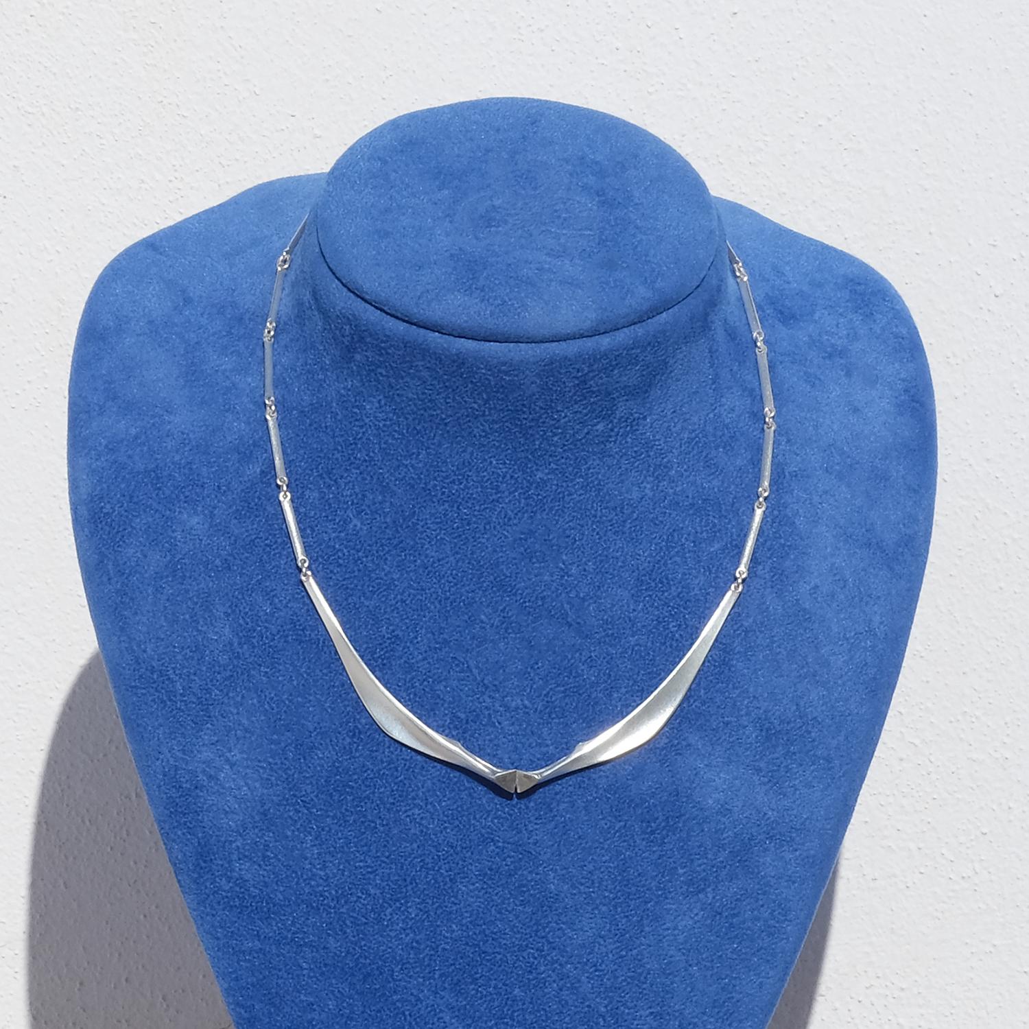 This sterling silver necklace has a brushed, matte surface and a ring and bar chain. In its front it is adorned with a pendant resembling silver wings. The necklace closes easily with a hasp.

This is a typical day to day necklace.

Do you know that