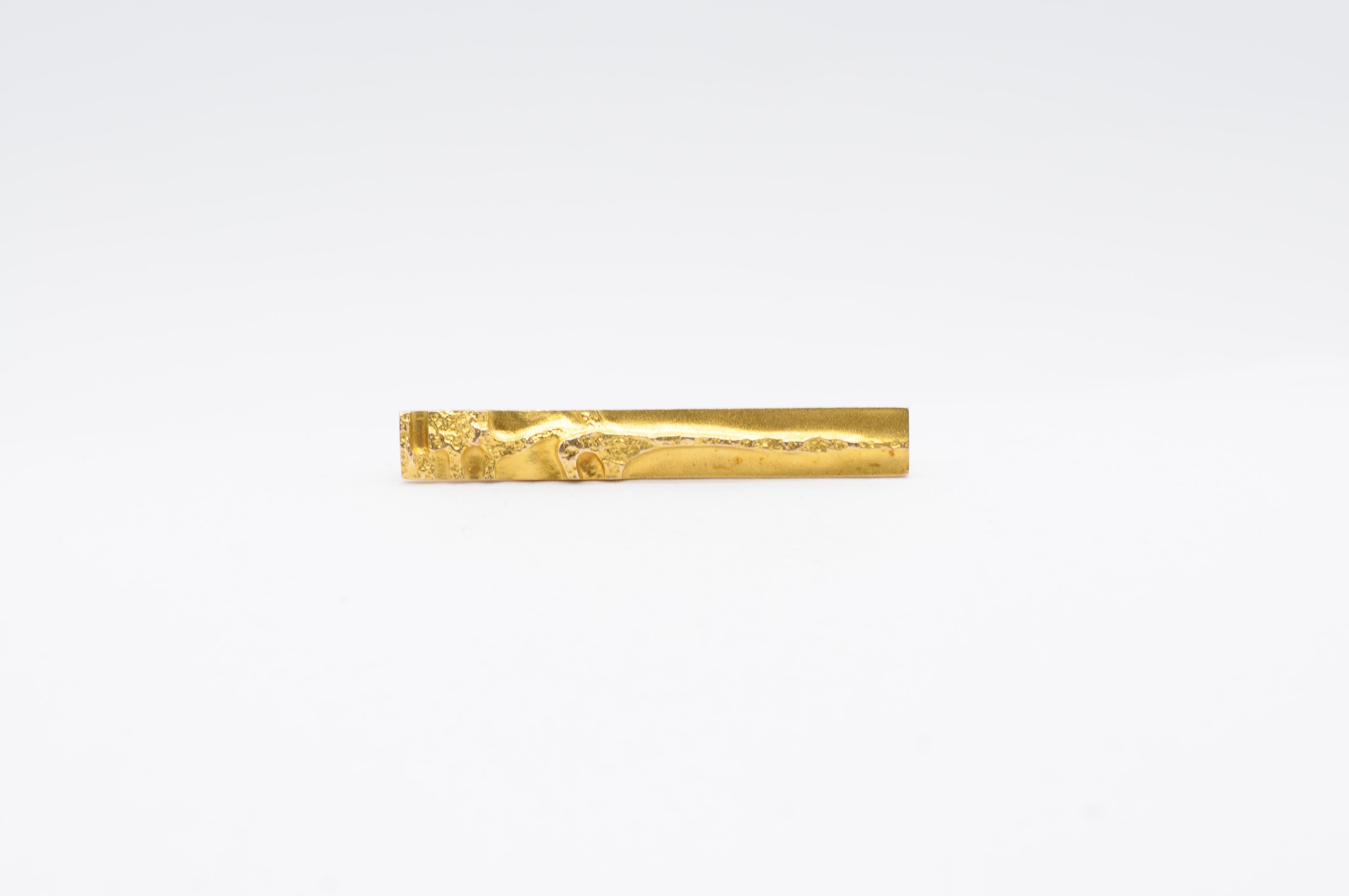 Indulge in the timeless elegance of Lapponia with this exquisite tie clip. Crafted by Lapponia, a renowned brand from Finland, this tie clip features a beautifully simple yet sophisticated design. Made from 18k yellow gold, it exudes a luxurious