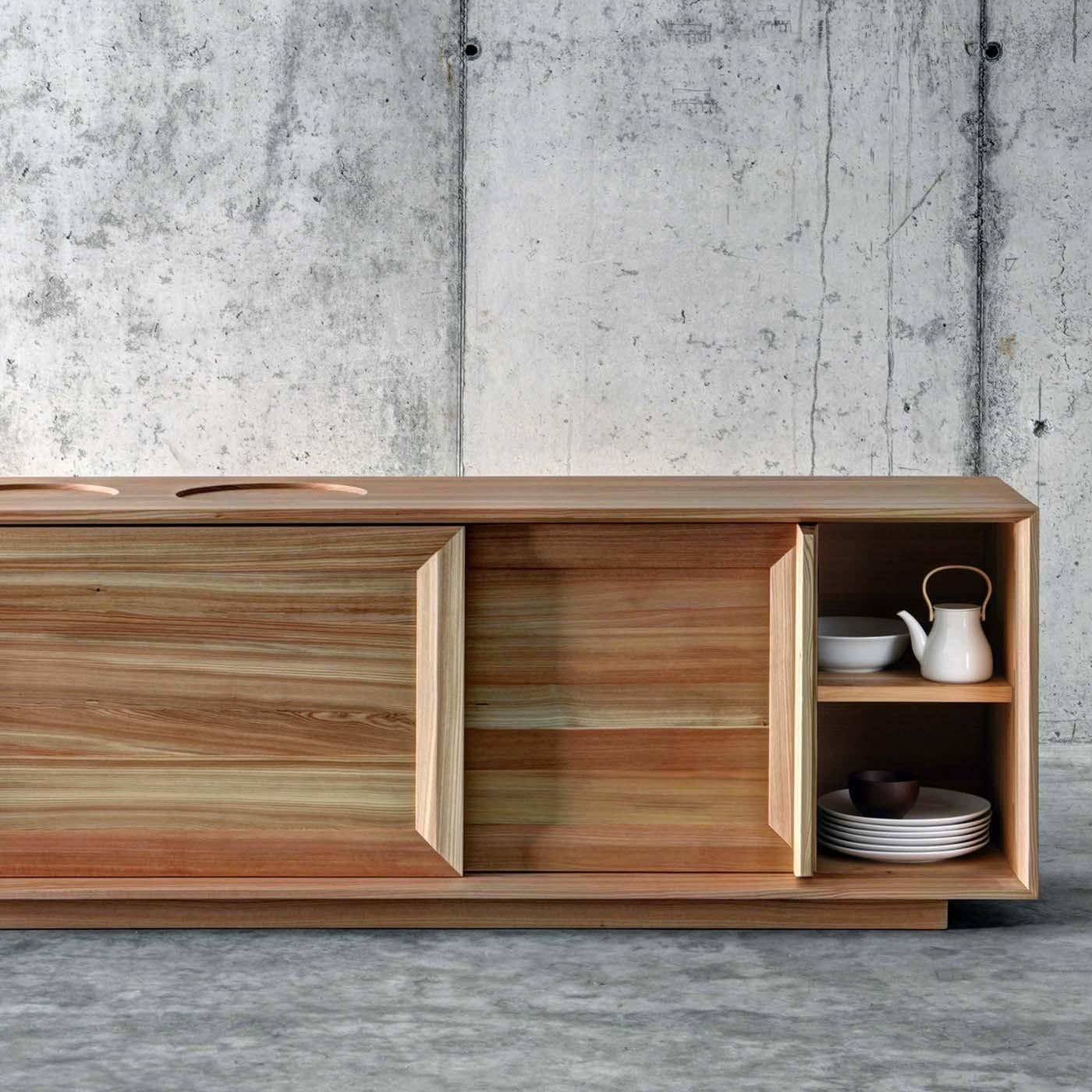 Designed by Act_Romegialli, this elegant and timeless cupboard will be a striking presence in any home. Its rectangular shape was crafted entirely of solid larch with the front featuring two sliding framed doors with tapered wood handles that open