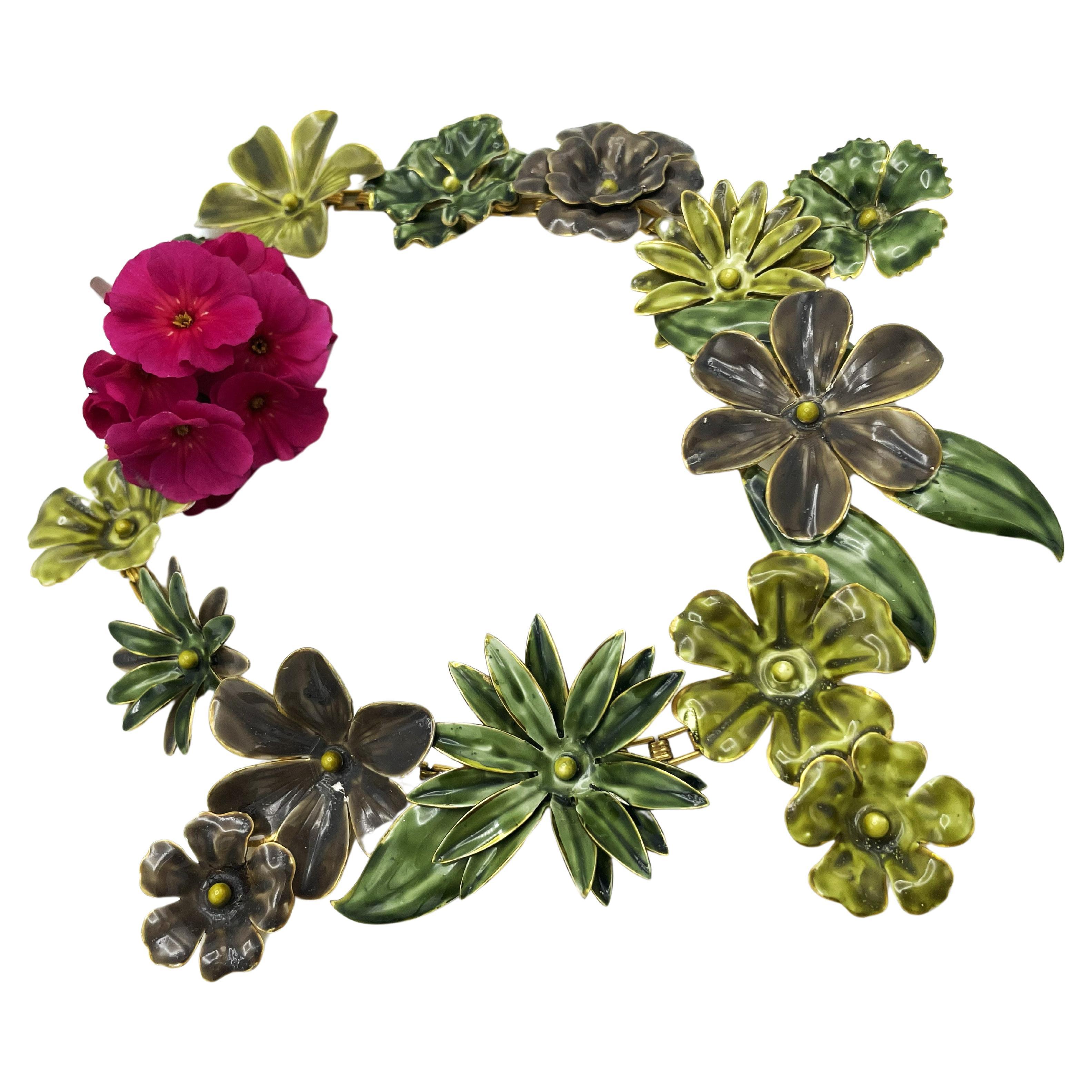 Un grand collier de fleurs et de feuilles en métal émaillé à la main, conçu par Sandor dans les années 1940, avec un clip d'oreille assorti en forme de fleur, datant des années 1940.
Sandor a fabriqué des bijoux artisanaux de haute qualité de la fin