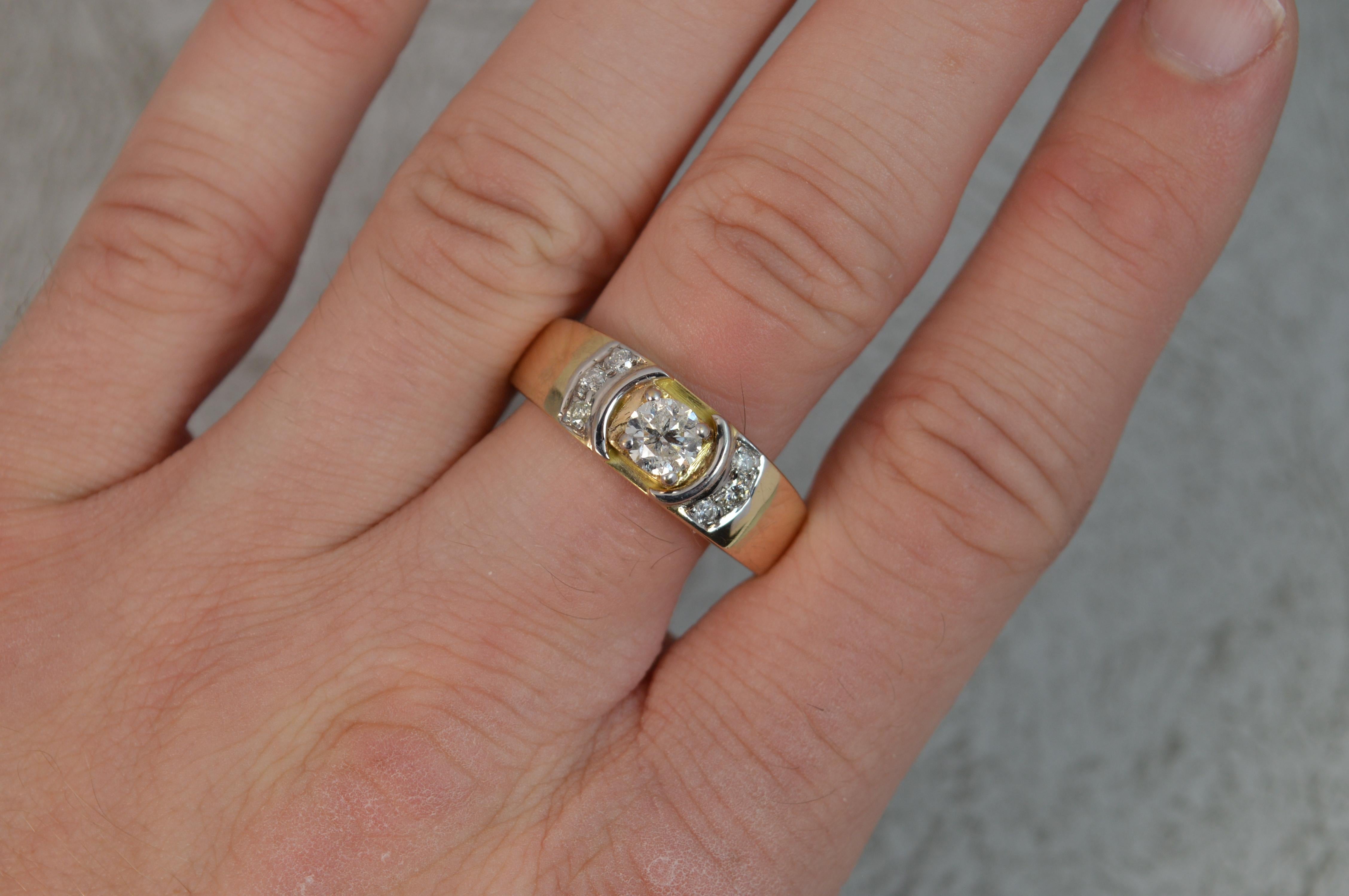 A large natural diamond and 9 carat gold ring.
Designed with a 0.6 carat natural round brilliant cut diamond to centre in four claw white gold setting. To each side are three round cut diamonds in curves, also in white gold.
Total weight approx 0.75