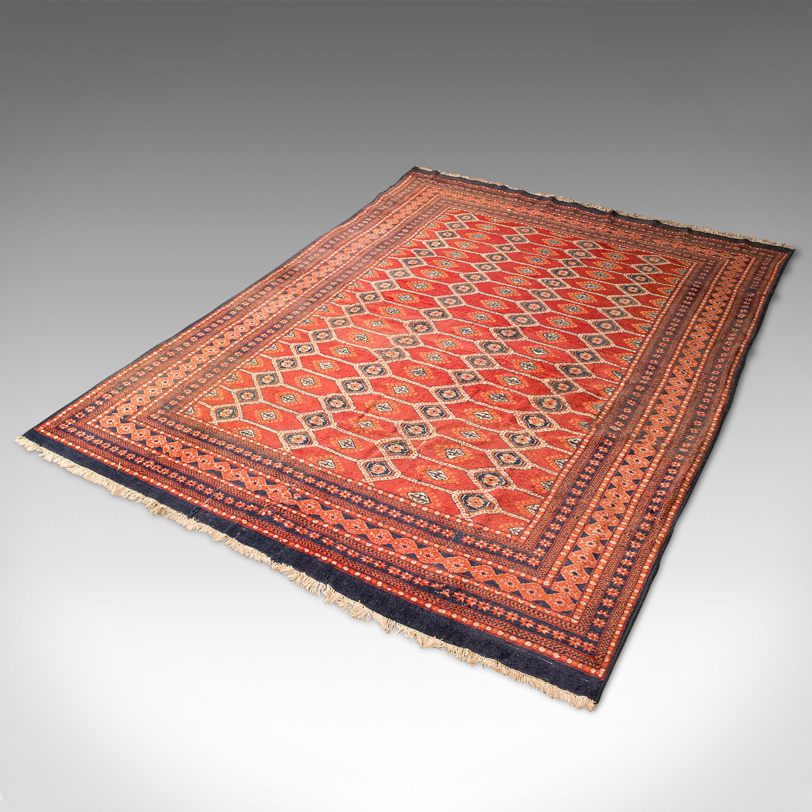 This is a large vintage Bokhara rug. A Middle Eastern, woven hall or living room carpet, dating to the late 20th century, circa 1970.

Generously sized Qali at 308cm (1214.25