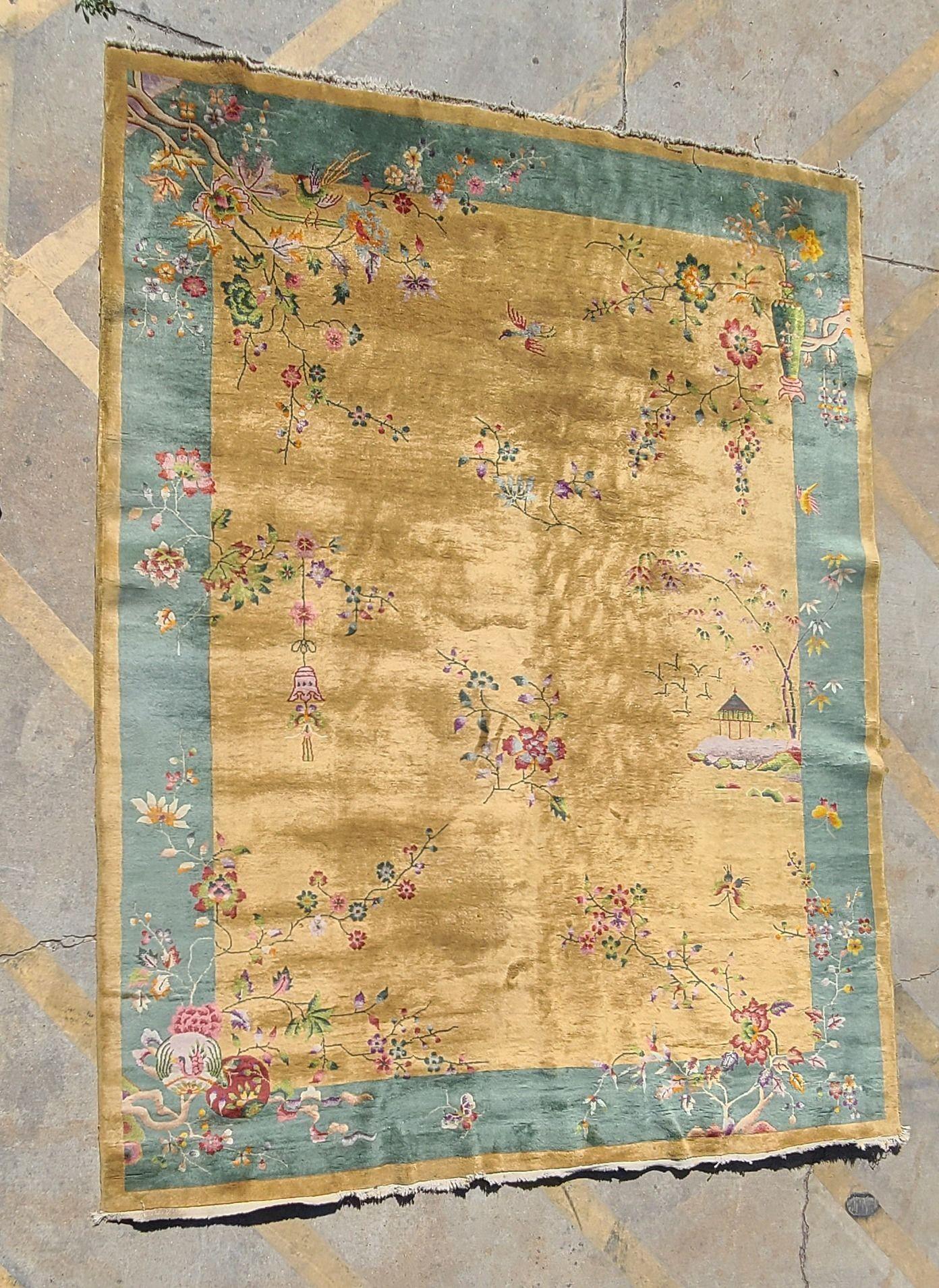 Large Wool on cotton Art Deco era Nichols-style Chinese area rug with Blue and gold border decorated with pagoda structures, boats/water, and floral motifs on a gold field centering floral.

Measurements: 11.5' X 9'

Circa 1930, China