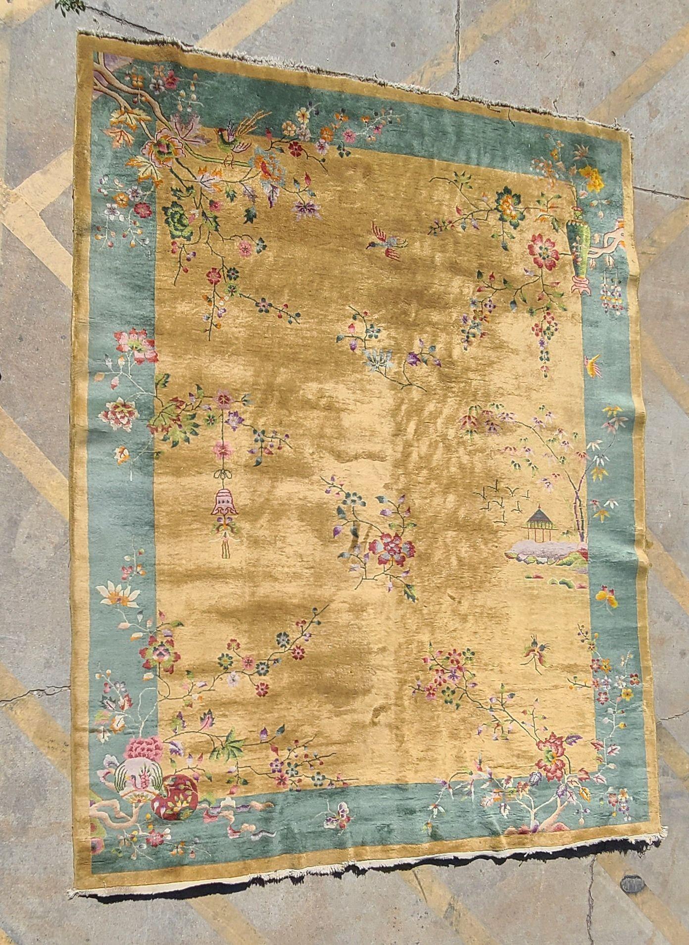 Grande tappeto cinese in lana e cotone in stile Nichols Rugs di epoca Deco con bordo blu e oro decorato con strutture a pagoda, barche/acqua e motivi floreali su un campo d'oro con centro floreale.

Misure: 11.5' X 9'

Circa 1930, Cina