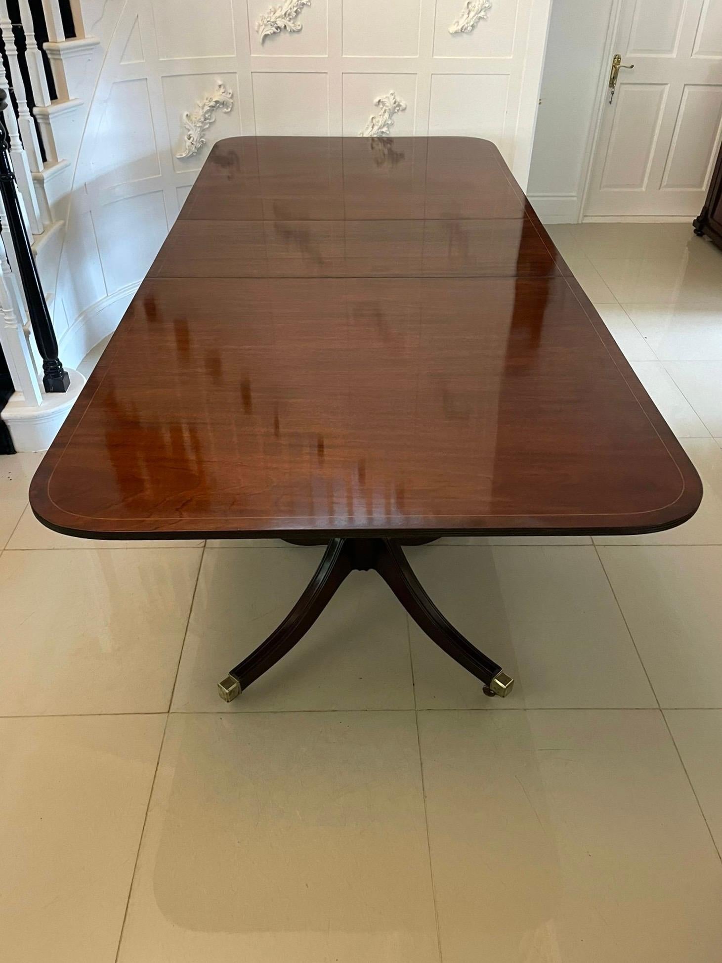 Grande table de salle à manger à deux piliers en acajou de qualité ancienne, 12 places, avec un plateau à bandes croisées en acajou figuré de qualité et une feuille supplémentaire d'origine, soutenue par deux colonnes à piédestal reposant sur quatre