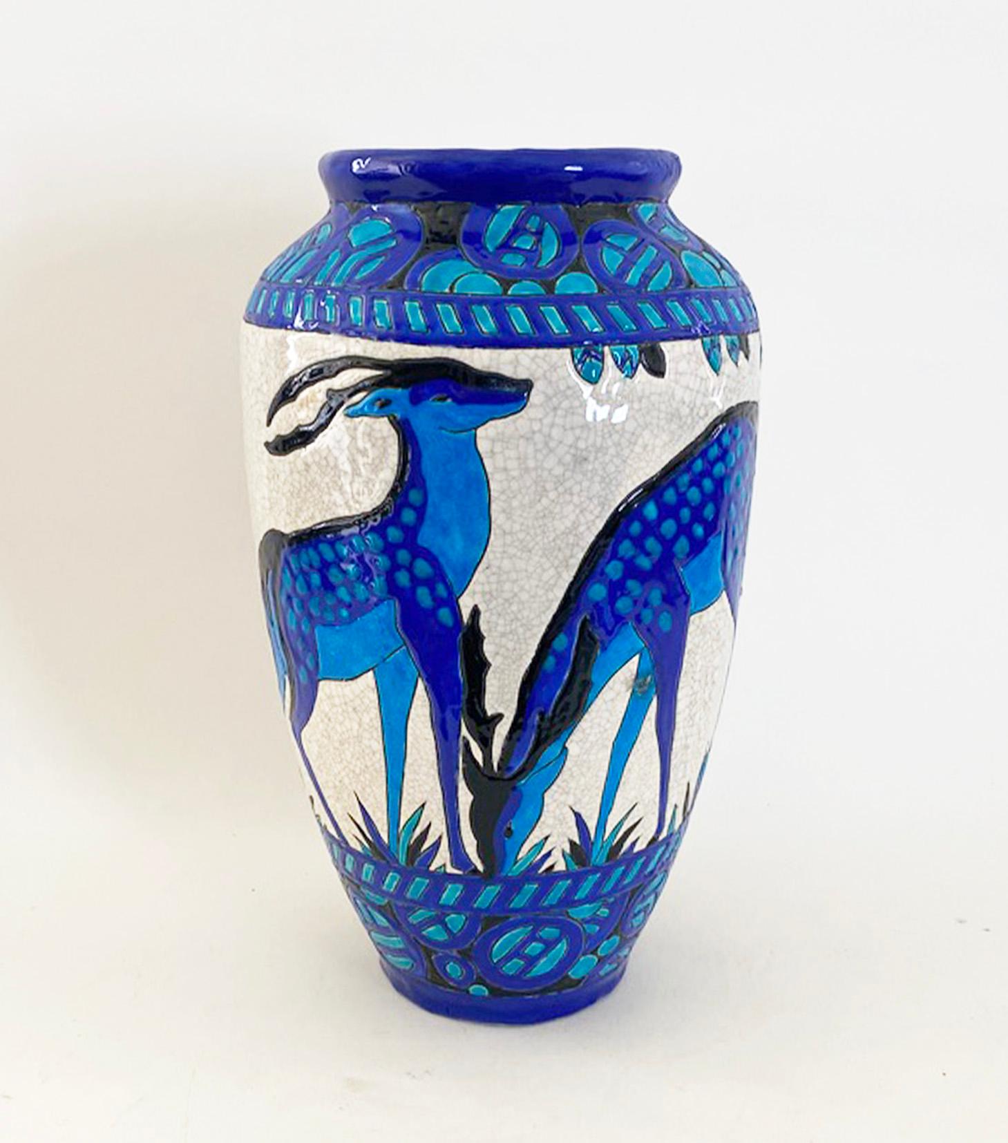 Voici un magnifique vase de Charles Catteau pour Boch Frères La Louviers, Belgique. Le vase représente quatre cerfs différents entourés de feuillage sur fond de glaçure craquelée. Il est signé et numéroté sur la face inférieure.

L'état est bon - il