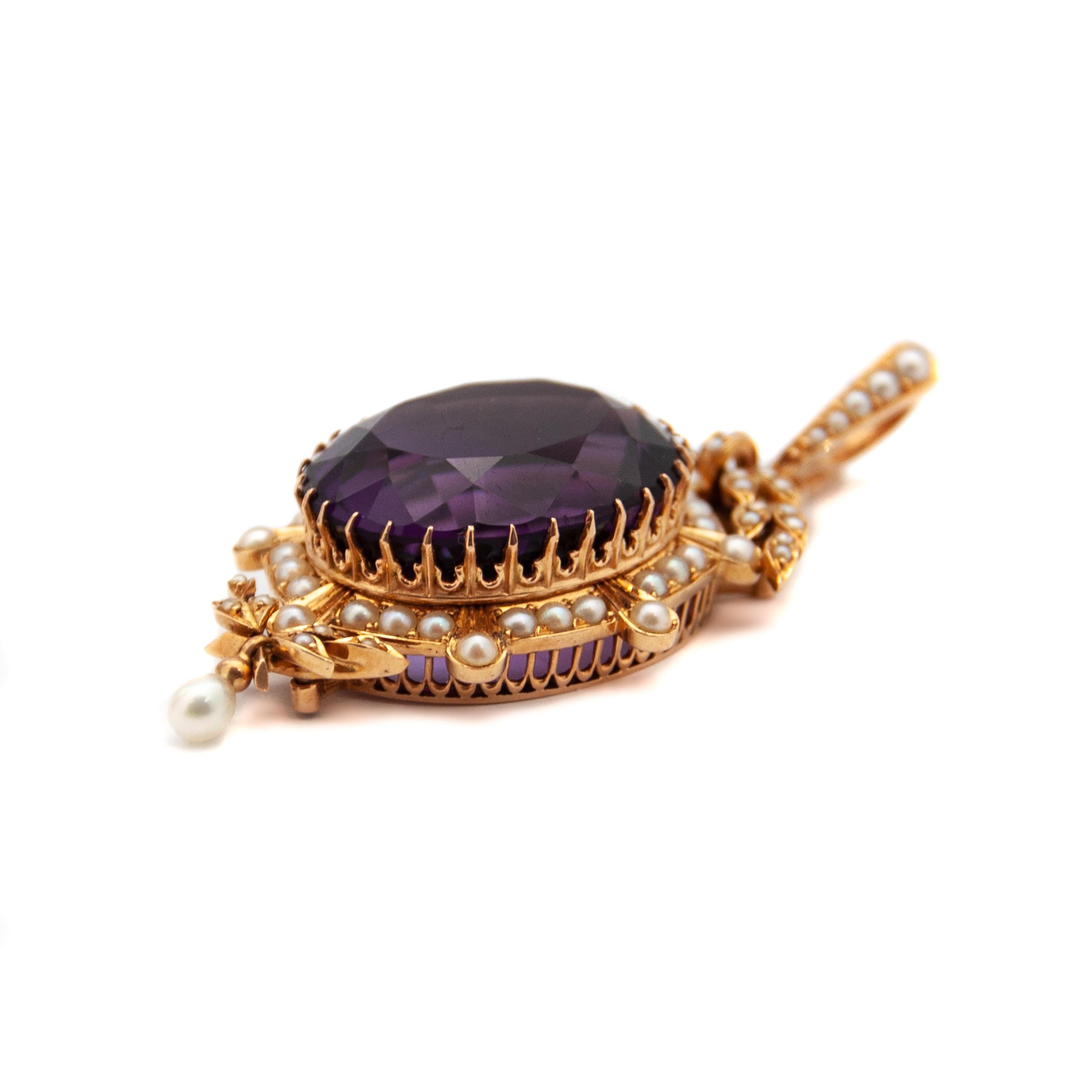 Large oval-shaped 14 karat yellow gold amethyst and pearl pendant. The pendant has a large faceted amethyst with a rim set of 67 clear seed pearls. At the top and bottom the leaves are encrusted with pearls. The pendant has a hinged eye at the top,