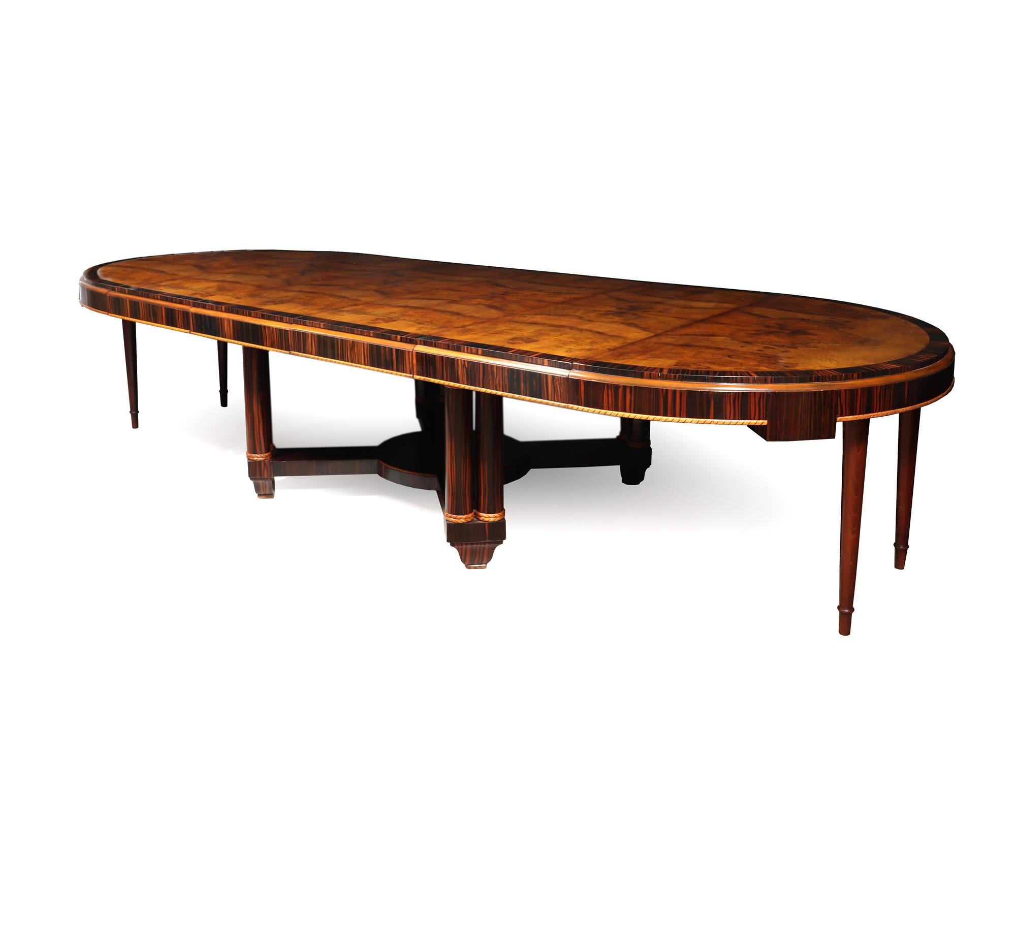 ART DECO DINING TABLE 
A truly exquisite French Art Deco extendable dining table from 1925. This rare beauty features a stunning circular top made of Macassar Ebony, with book matched burr walnut centre and blonde wood pie crust detailing. Standing