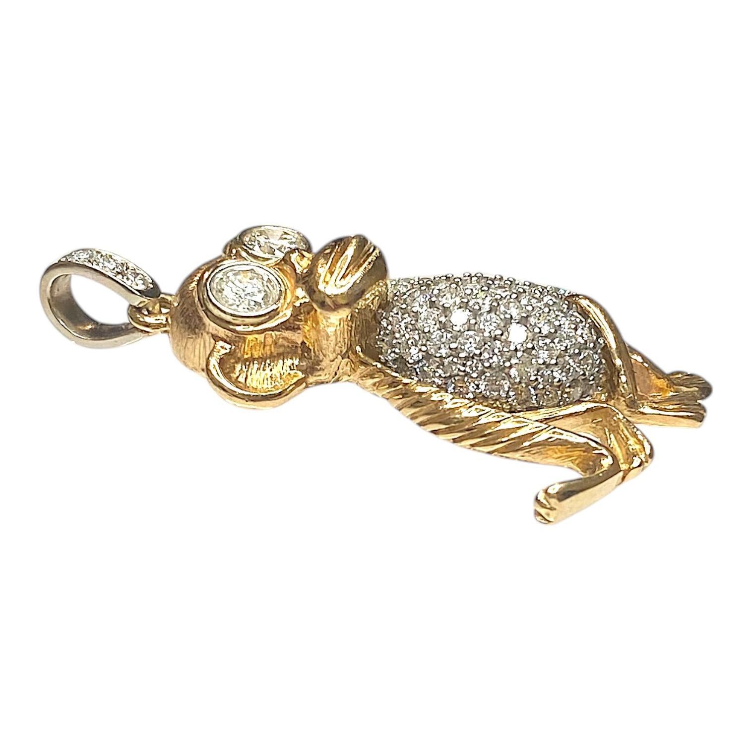 Crafted in 14K yellow and white gold, this pendant features a whimsical monkey design adorned with brilliant-cut diamonds. The eyes are set with two bezel set diamonds totaling 1.1 carats, with an I1 clarity and H color grade. The body and tail are
