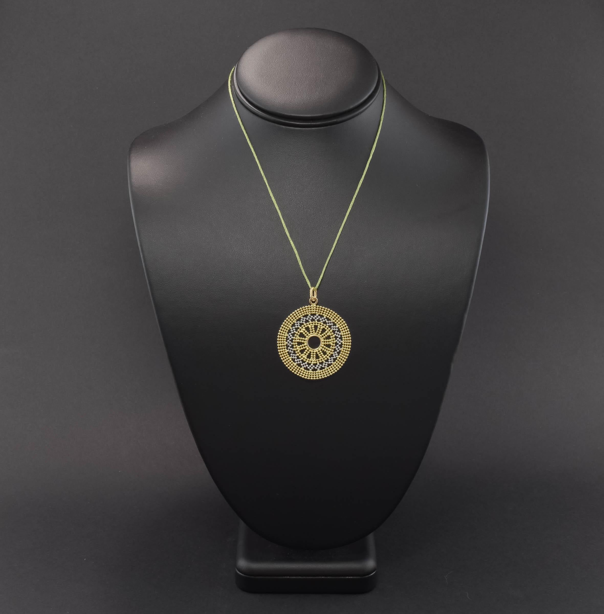 What a fun vintage piece!

Made in Italy of 14K yellow and white gold, this very large pendant resembles a mandala, I think.  It's cleverly made of small gold beads, giving the piece some flexibility so it almost feels like stiff metal fabric, with